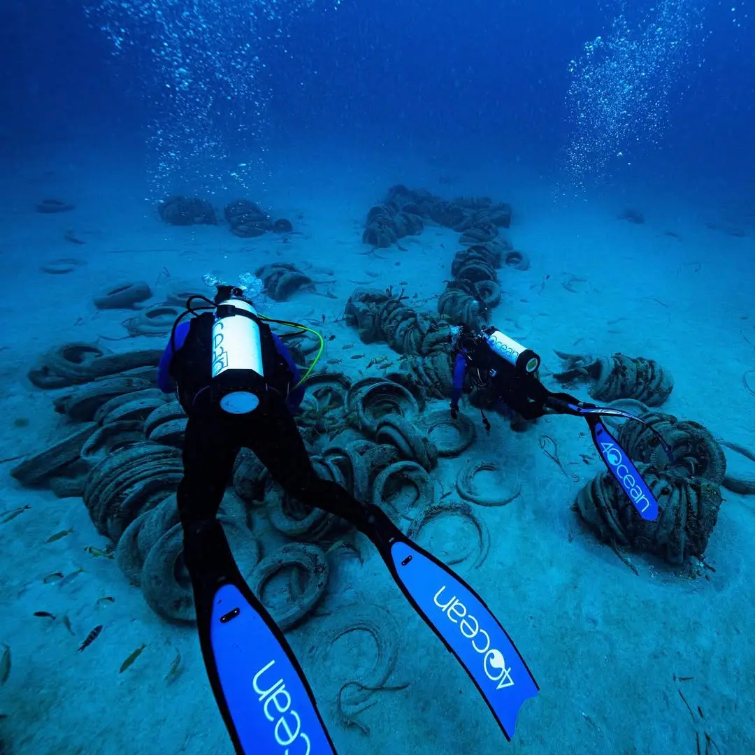 Diver trying to clean up the tyres (@4ocean)
