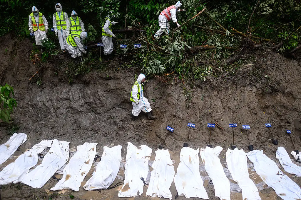 Mass burials for unidentified victims are also taking place (MANAN VATSYAYANA / AFP via Getty Images)
