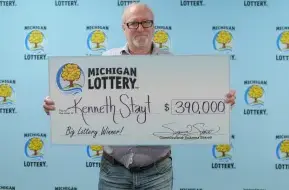 Kenneth with his winnings (Michigan Lottery)