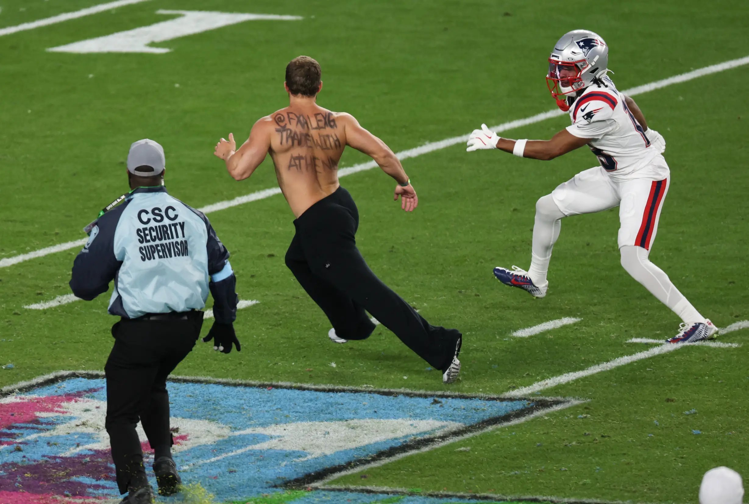 The phrase 'fxalexg Trade with Athena' can be seen on his body (T. Fallon / AFP via Getty Images)