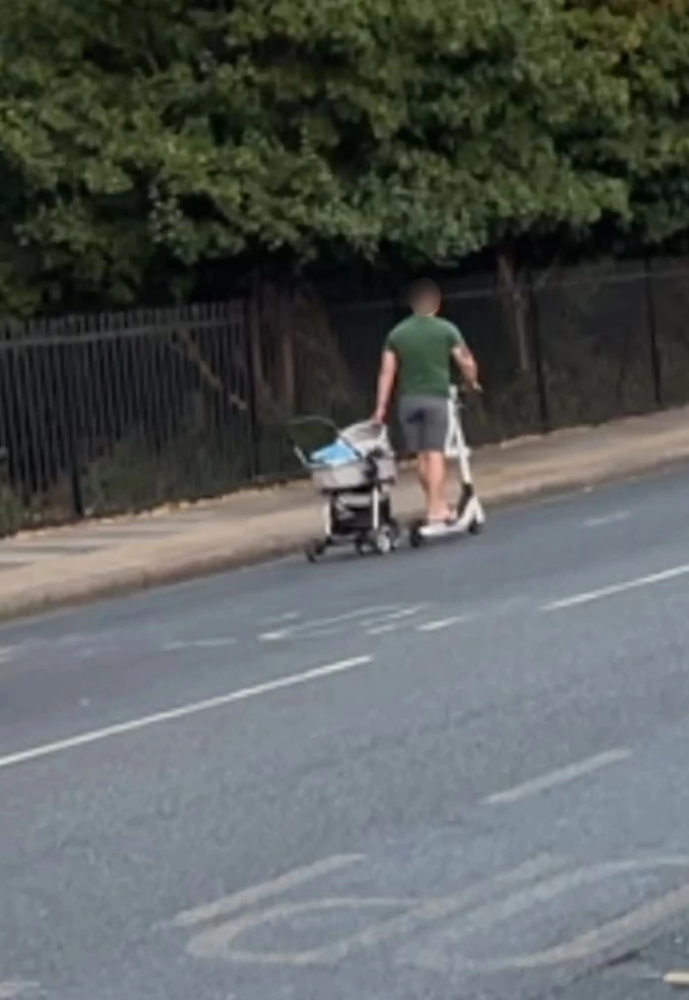The man was spotted wheeling a pram along the road while he was riding an e-scooter.