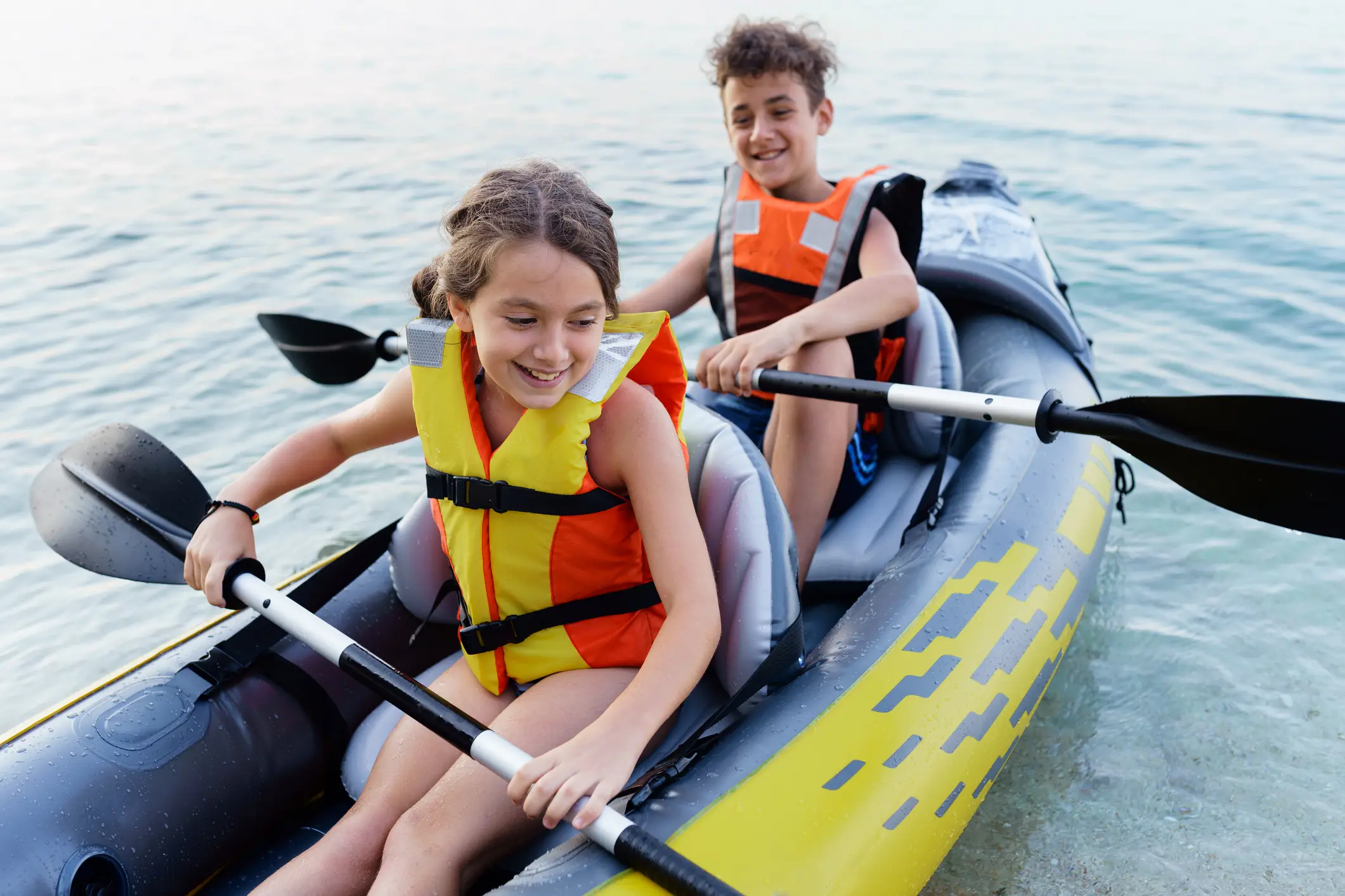 Teenagers having fun kayaking with inflatable raft on their summer vacation (MelkNimages/Gettys Images)