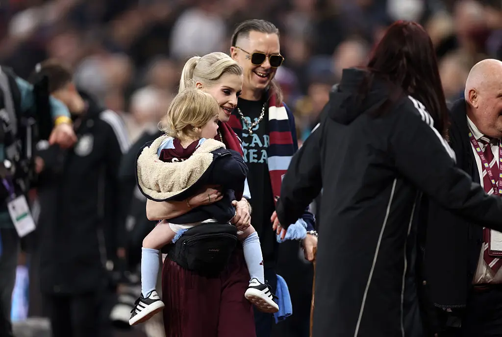 Sid Wilson and Kelly Osbourne with their son at Villa Park for Ozzy Osbourne's final gig with Black Sabbath (Amy Sussman/Getty Images)