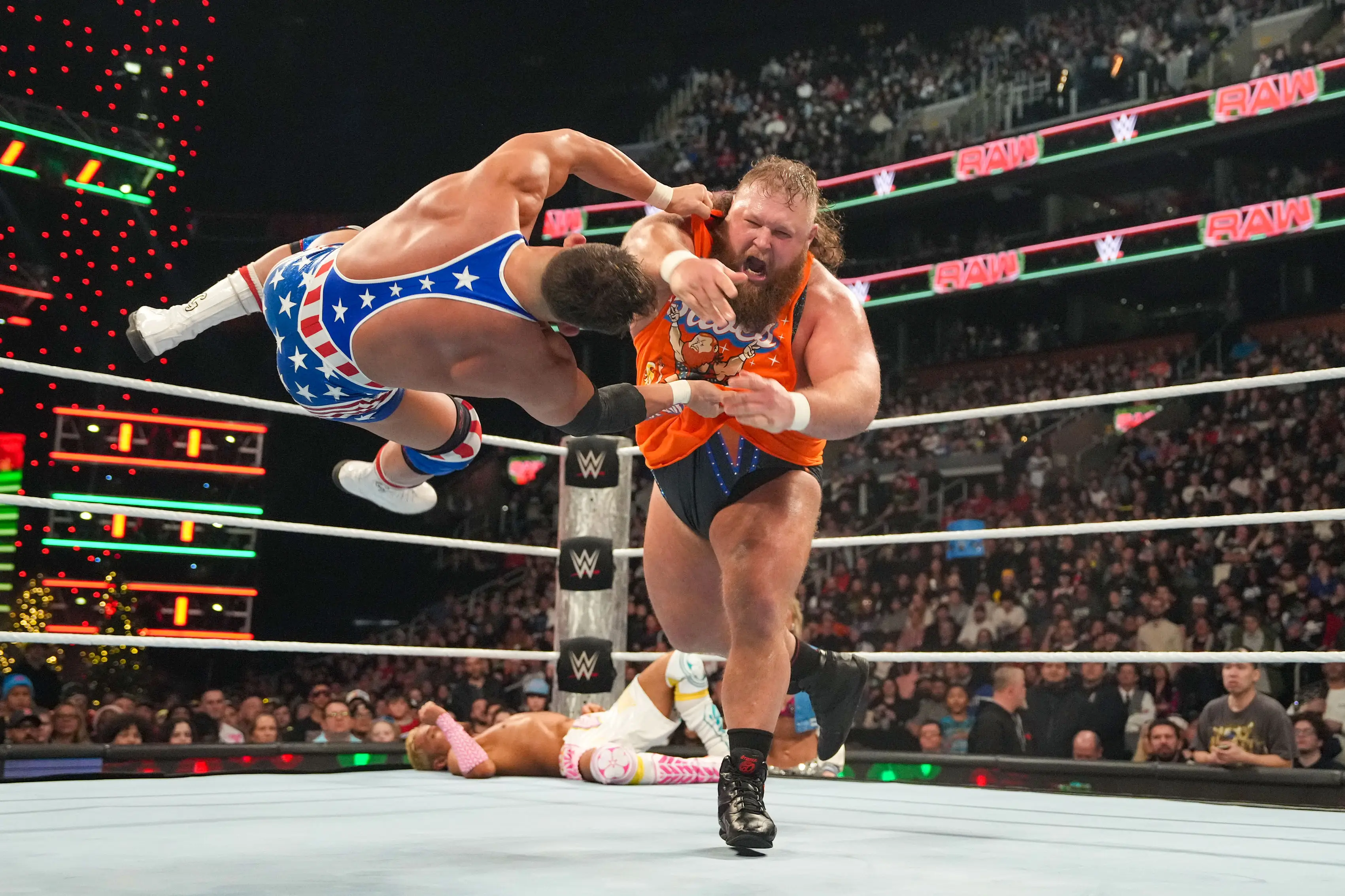 A WWE employee is under the ring while wrestlers are getting slammed around. Image: Getty