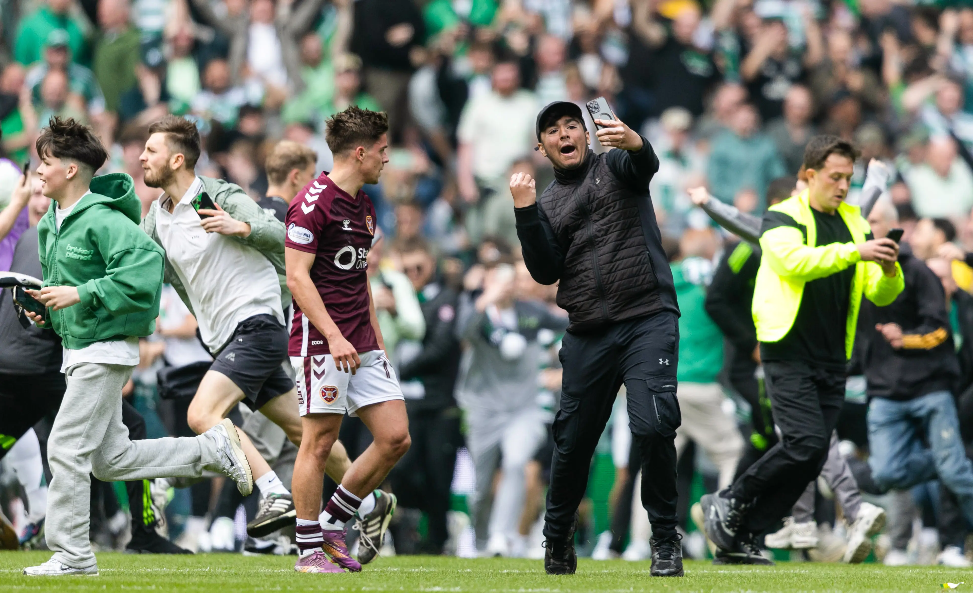 Hearts' Cammy Devlin and a Celtic fan during the game. Image credit: Getty