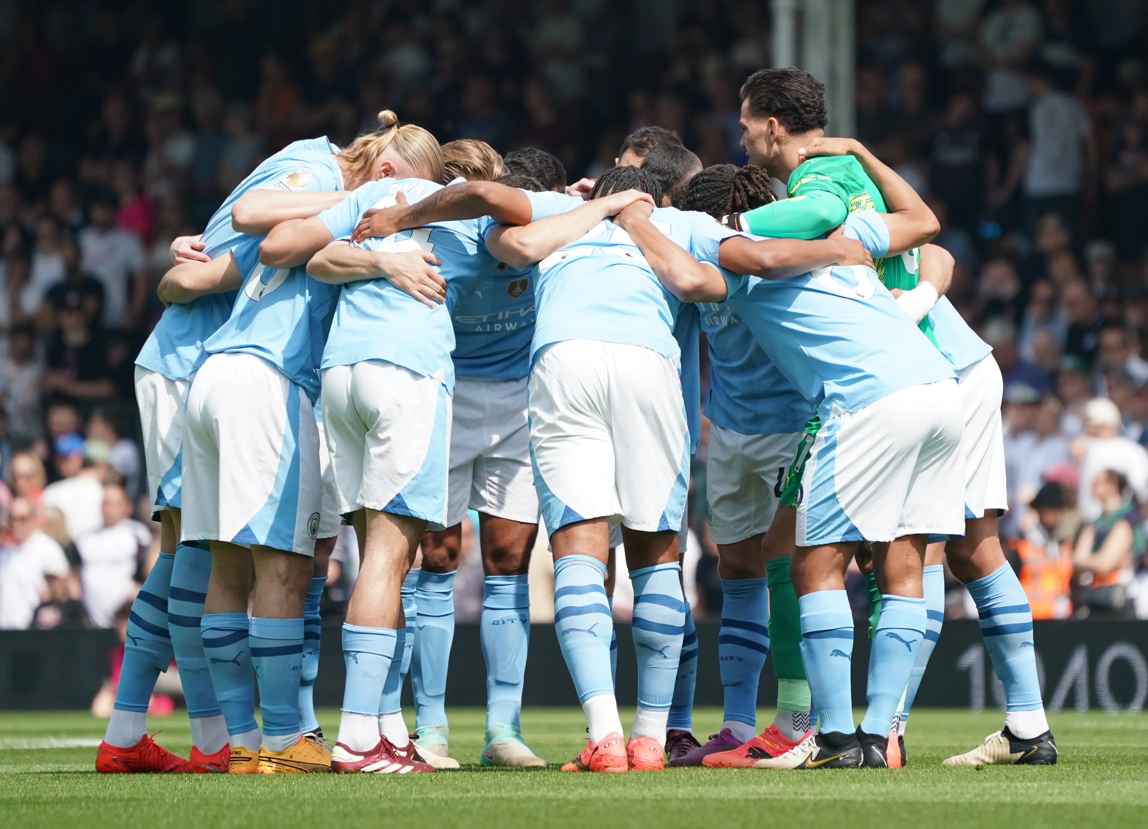 Manchester City team gather for a huddle before a Premier League game. Image: Getty