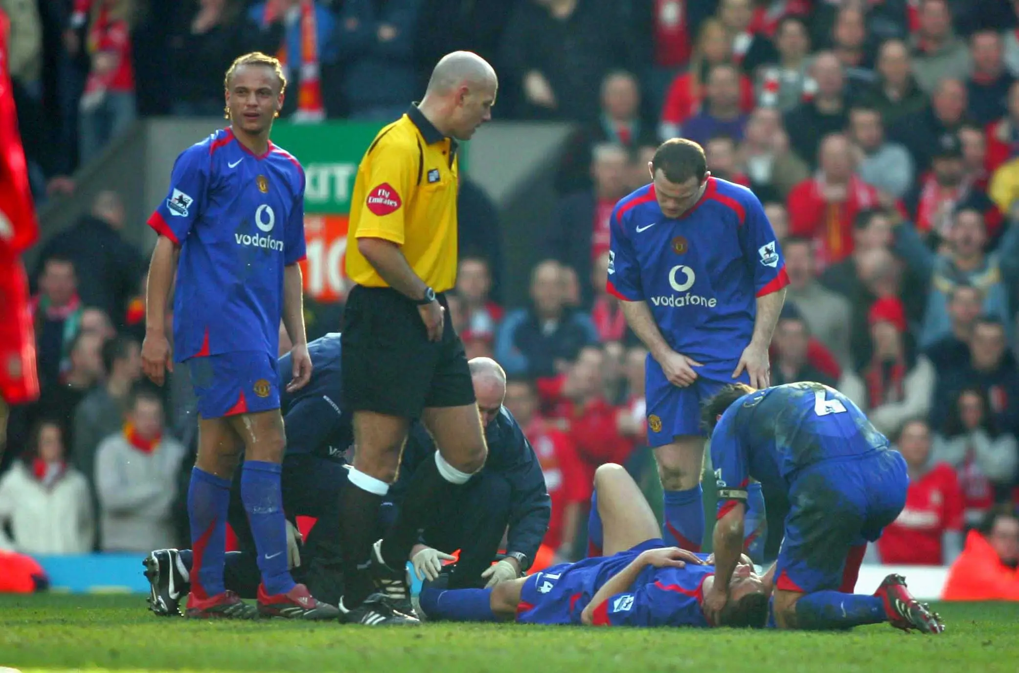 Smith, being held by Gary Neville, immediately after the leg break. (Image