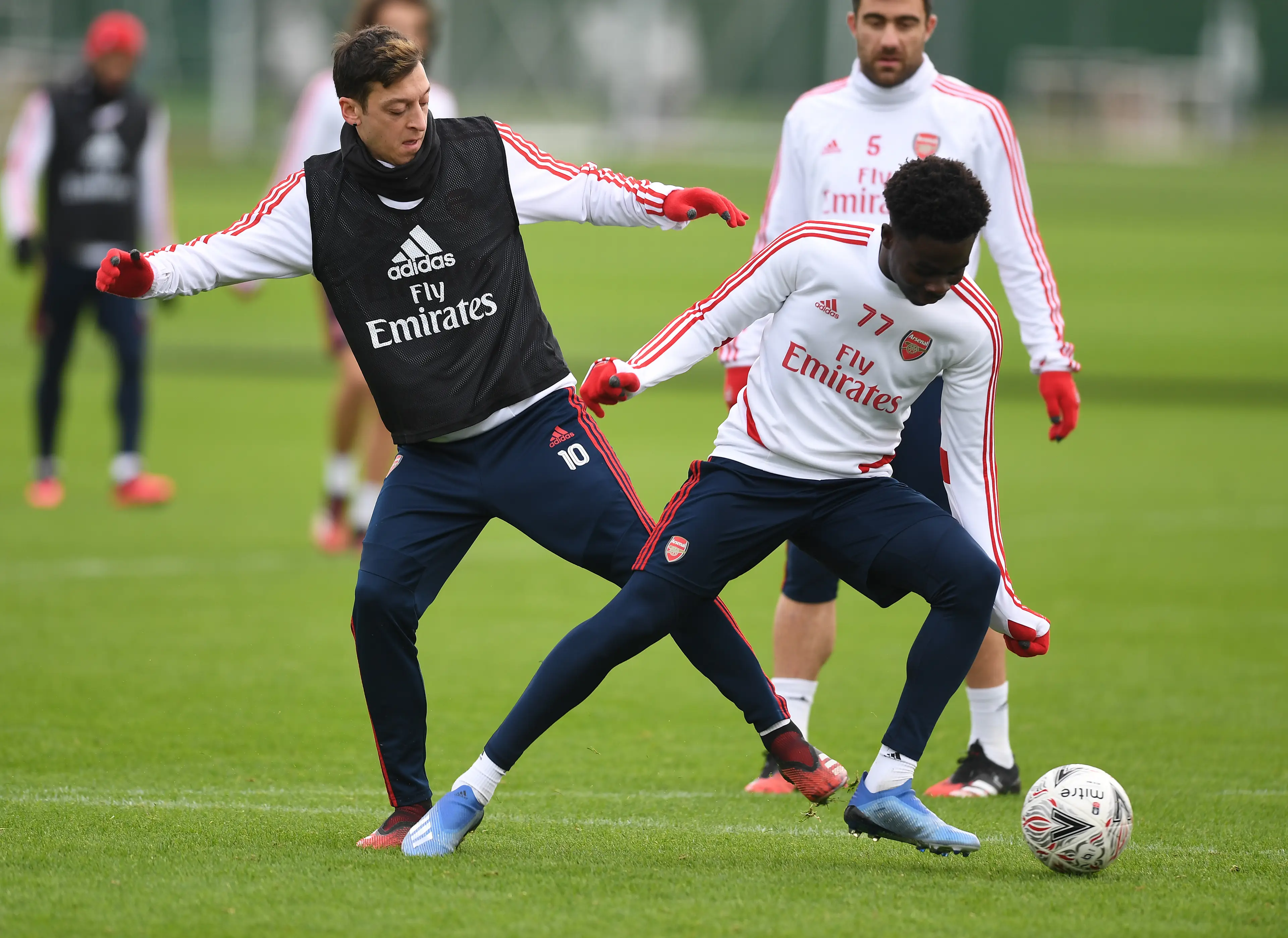 Mesut Ozil and Bukayo Saka. (Image: Getty)