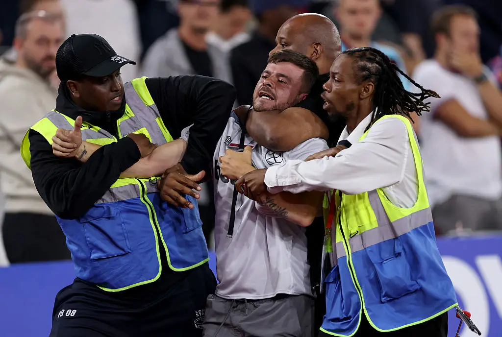 One West Ham fan was escorted from the pitch by security (Image: Getty)