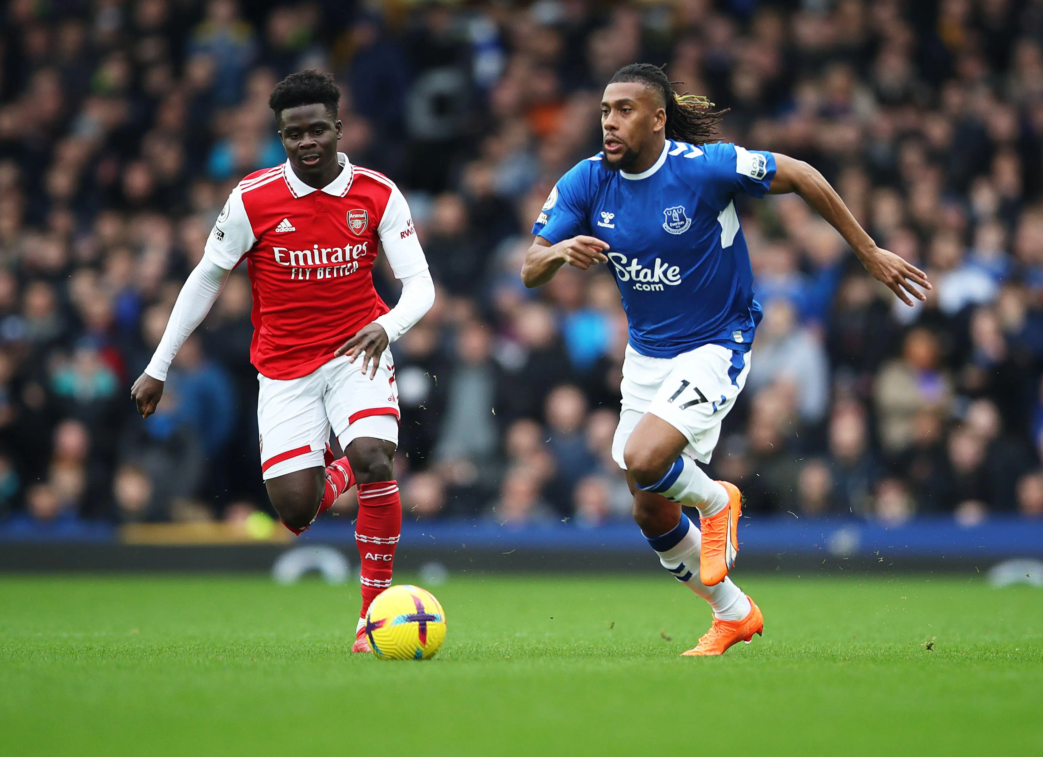 Everton midfielder Alex Iwobi dribbles away from Arsenal winger Bukayo Saka. (Image