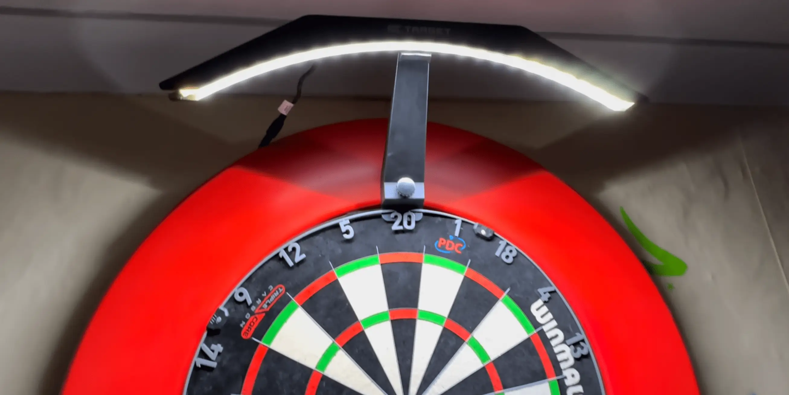 Darts lights are readily available to buy and attach to the board (Image: YouTube/Kevin Harnell Productions)