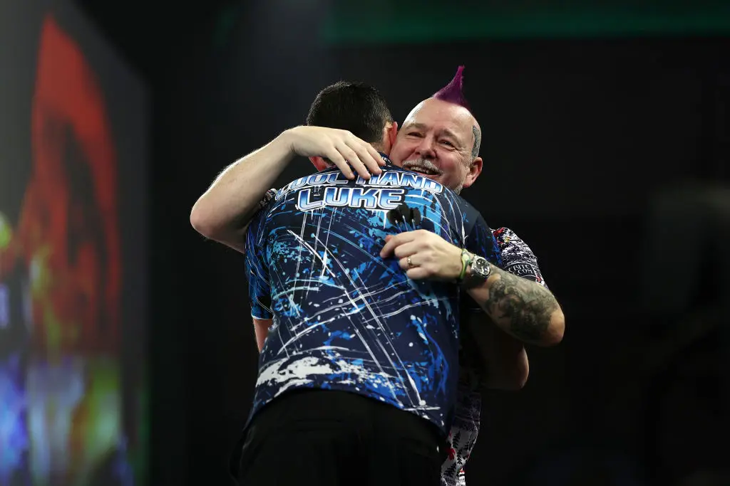 Luke Humphries embraces Peter Wright after their World Darts Championship fourth round match (Image: Getty)