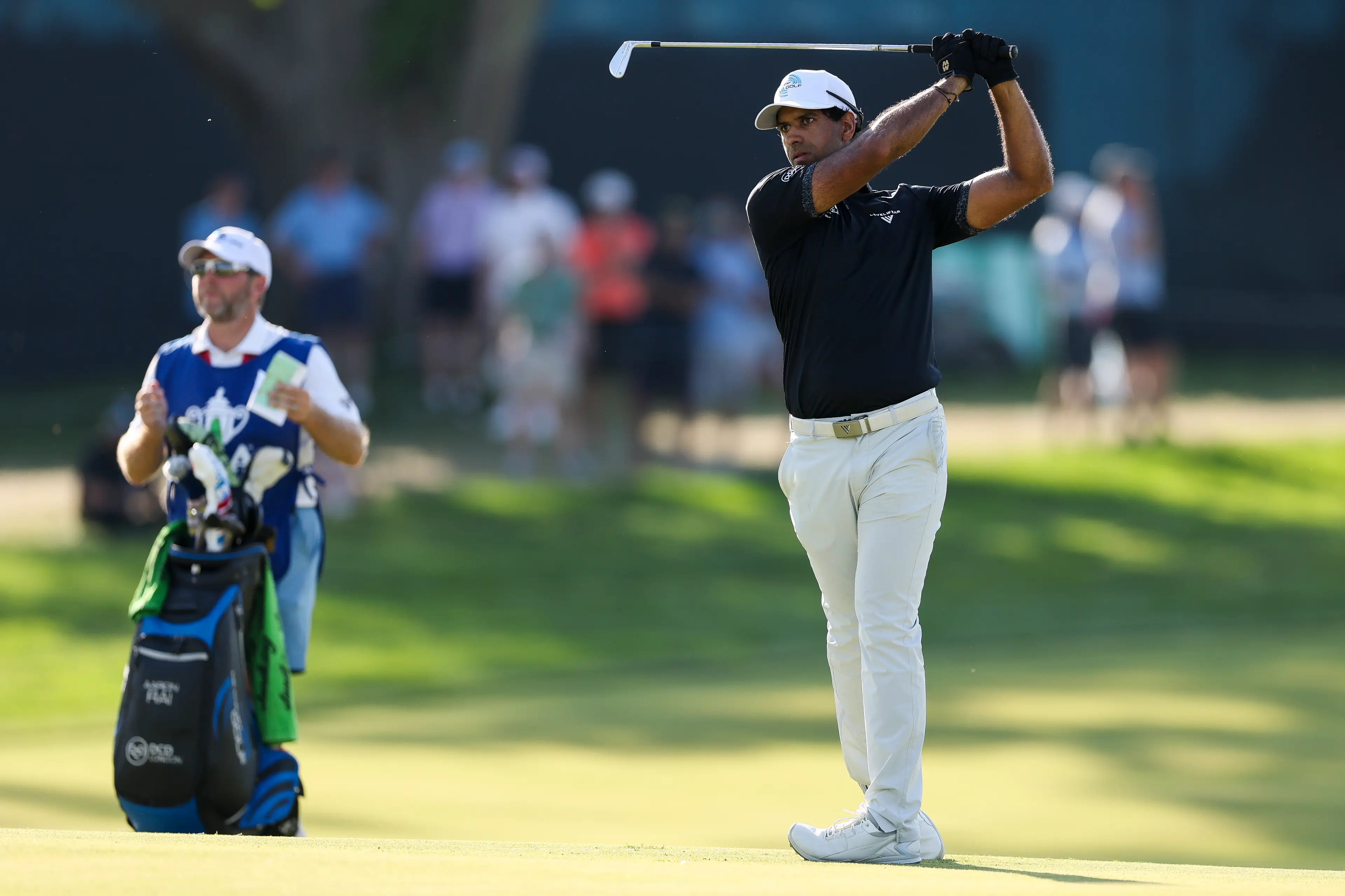 Rai wears two gloves and puts covers on his irons while playing golf. Image credit: Getty