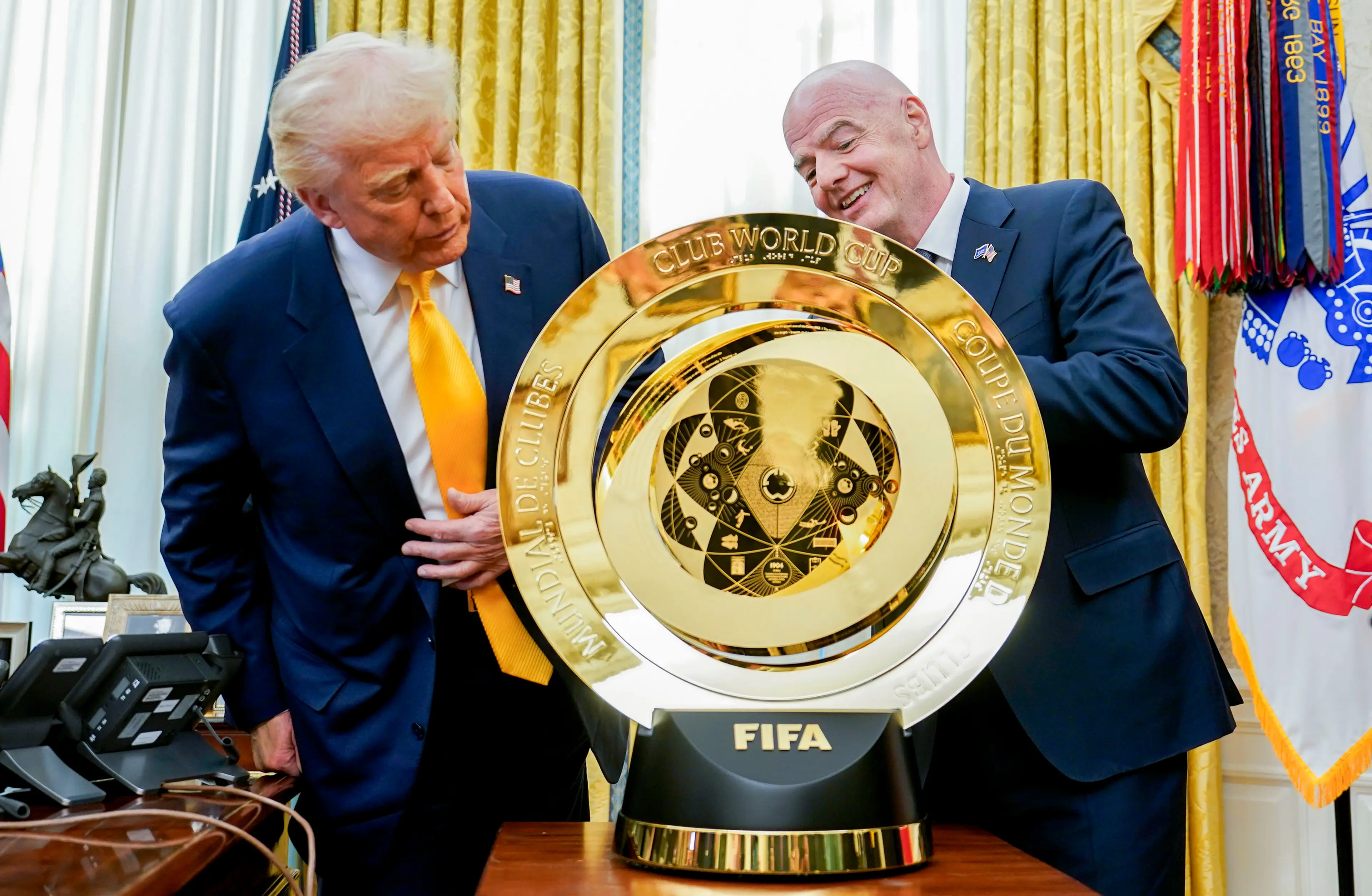 President Donald Trump and FIFA chief Gianni Infantino inspect the Club World Cup trophy. Image: Getty