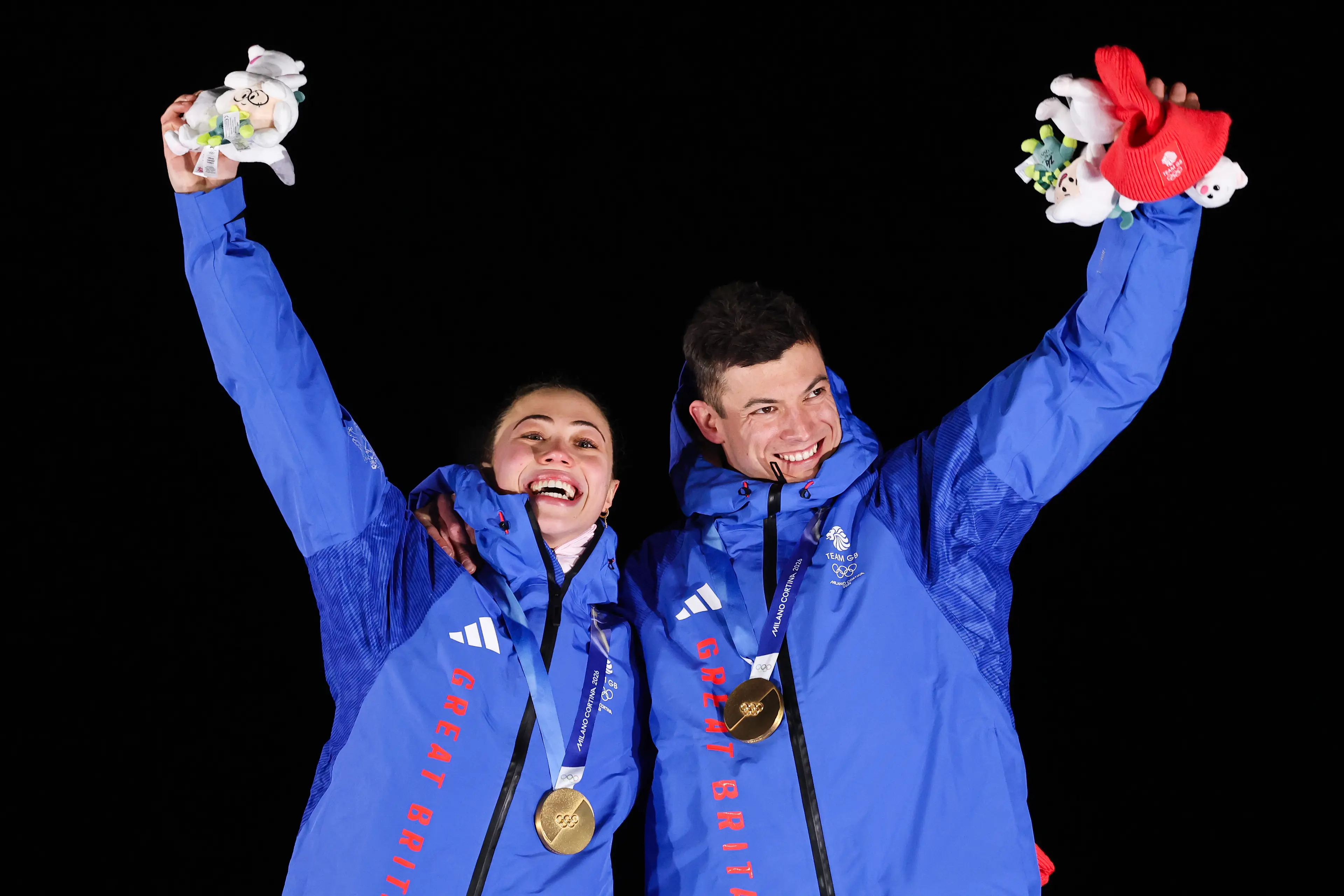 Matt Weston and Tabitha Stoecker celebrate winning gold on the podium at the Winter Olympics. Image: Getty 