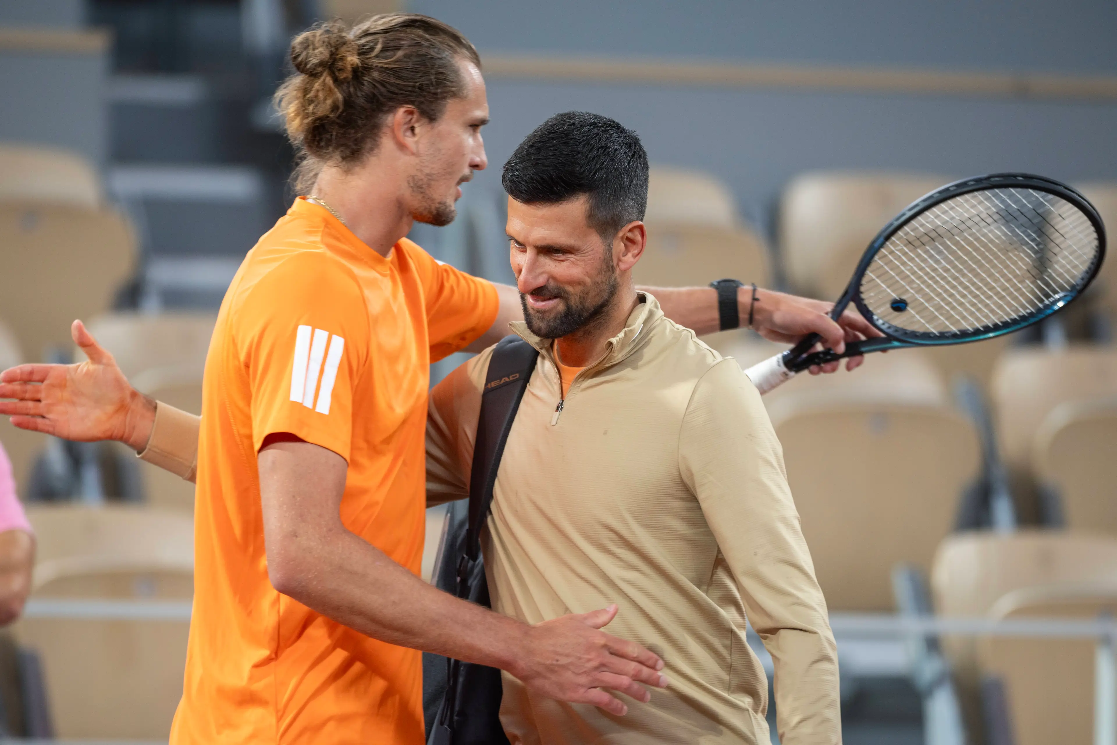 Alexander Zverev of Germany and Novak Djokovic of Serbia embrace as they meet on court for a practice session together on Court Philippe Chatrier (Getty Images)