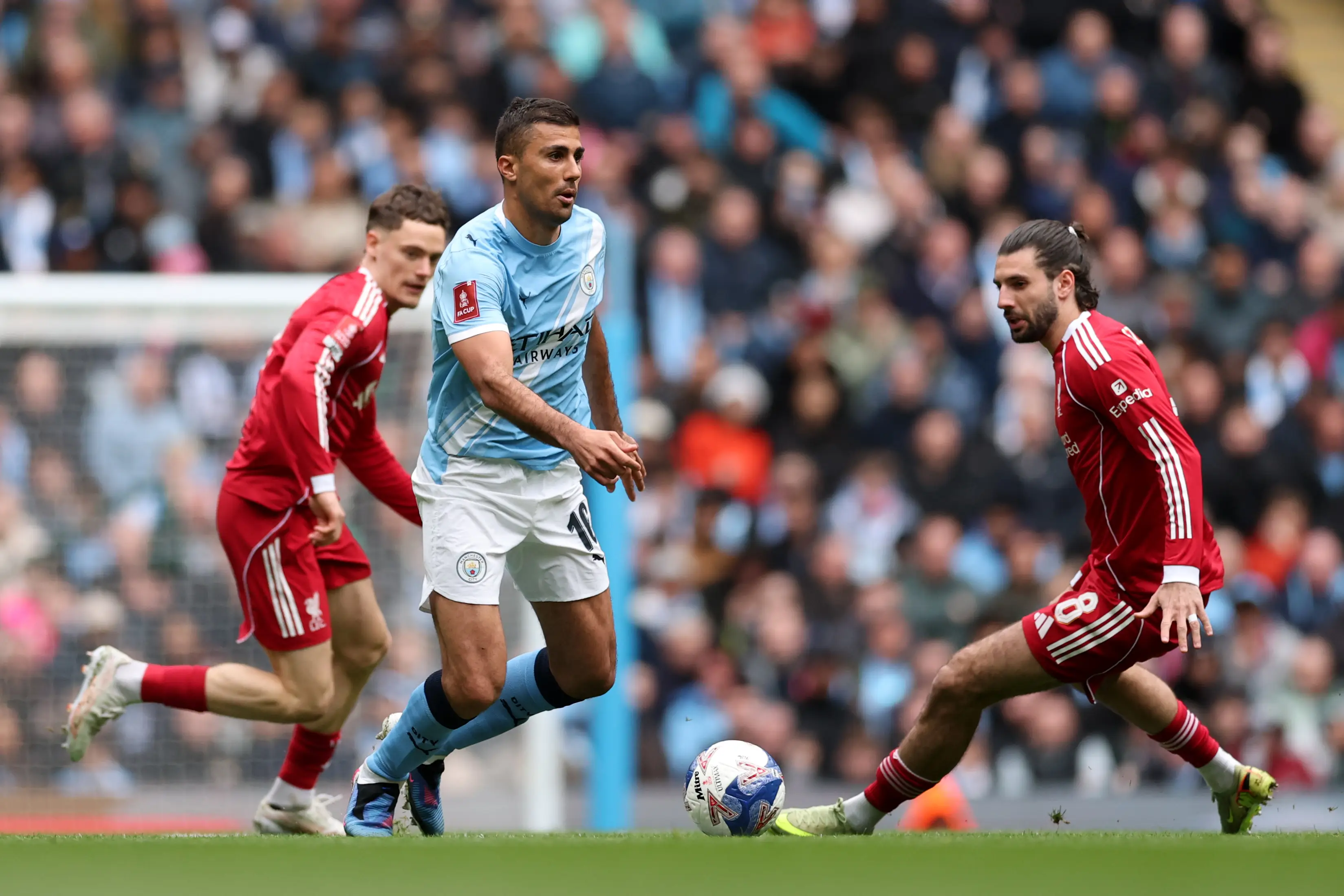 Rodri of Manchester City runs with the ball whilst under pressure from Dominik Szoboszlai during the Emirates FA Cup Quarter Final match between Manchester City and Liverpool (Getty Images)