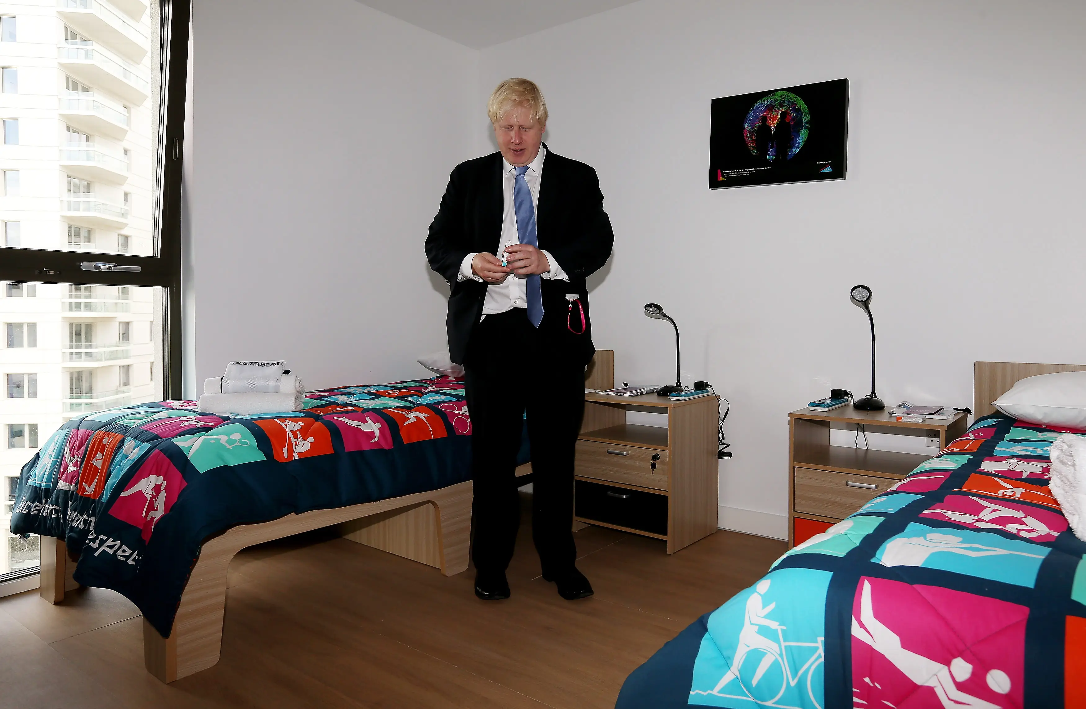 Boris Johnson observes the rooms at the Olympic village. Image: Getty