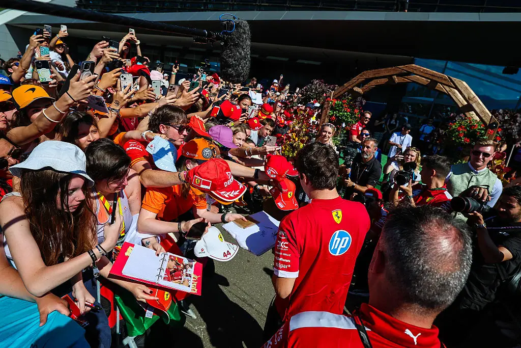Charles Leclerc of Ferrari signs autographs for fans in the paddock (Getty Images)
