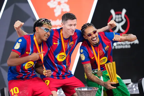 Yamal celebrates with team-mates Robert Lewandowski and Raphinha after Barcelona win the Supercopa de Espana (Image: Getty)