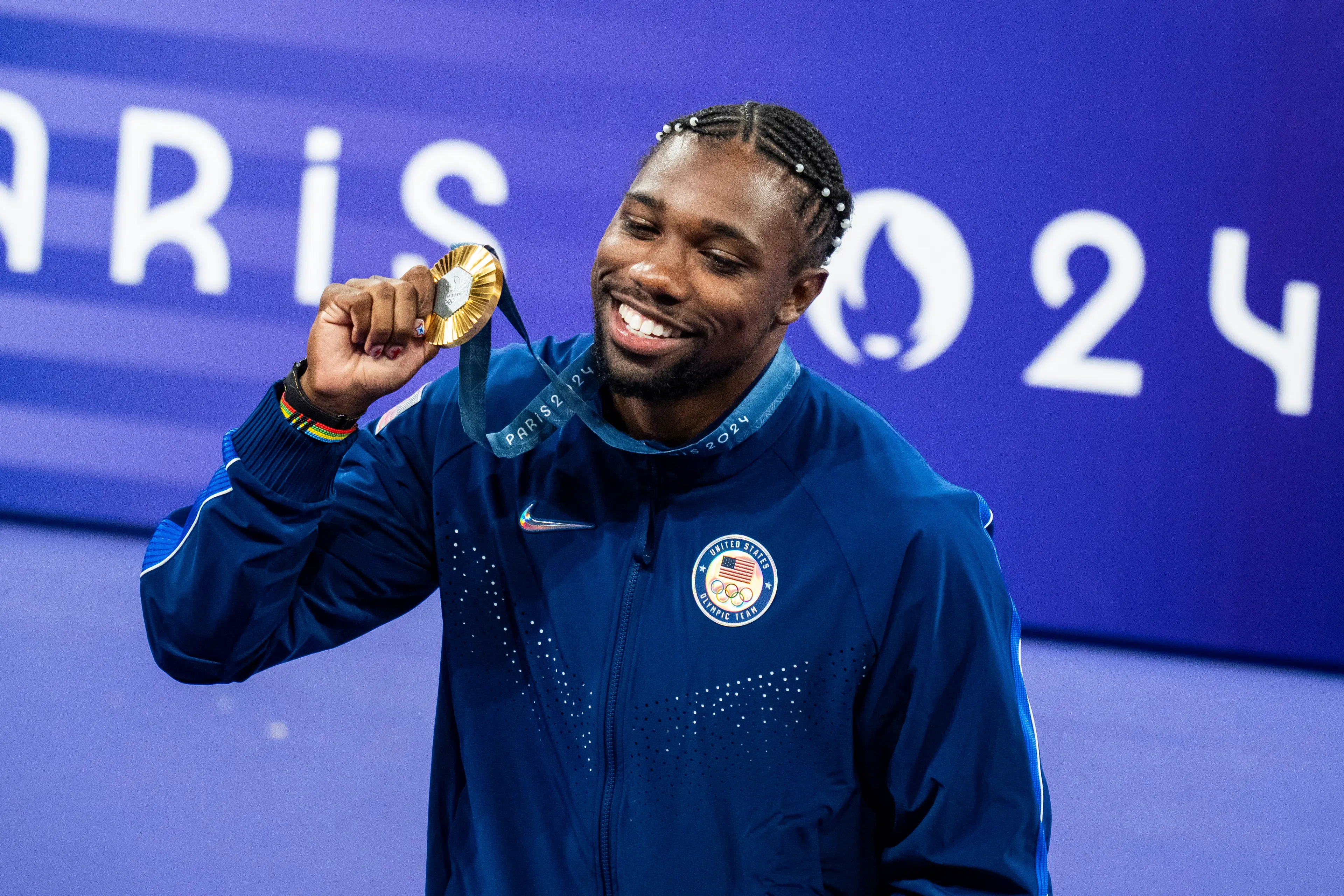 Noah Lyles celebrates on the podium after winning gold in Paris. Image: Getty