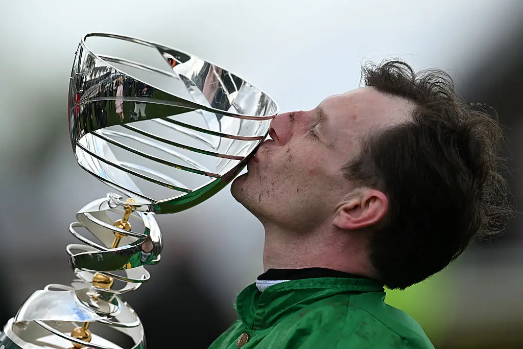 Jockey Paul Townend kisses the trophy at the presentation after riding I Am Maximus to victory in the Grand National. Image credit: Getty