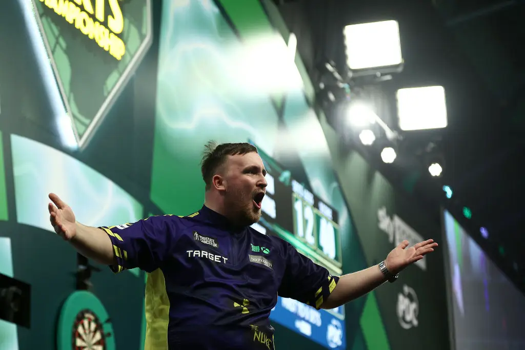 Luke Littler booked his place in the PDC World Championship final with a semi-final win over Stephen Bunting. (Image: Getty)