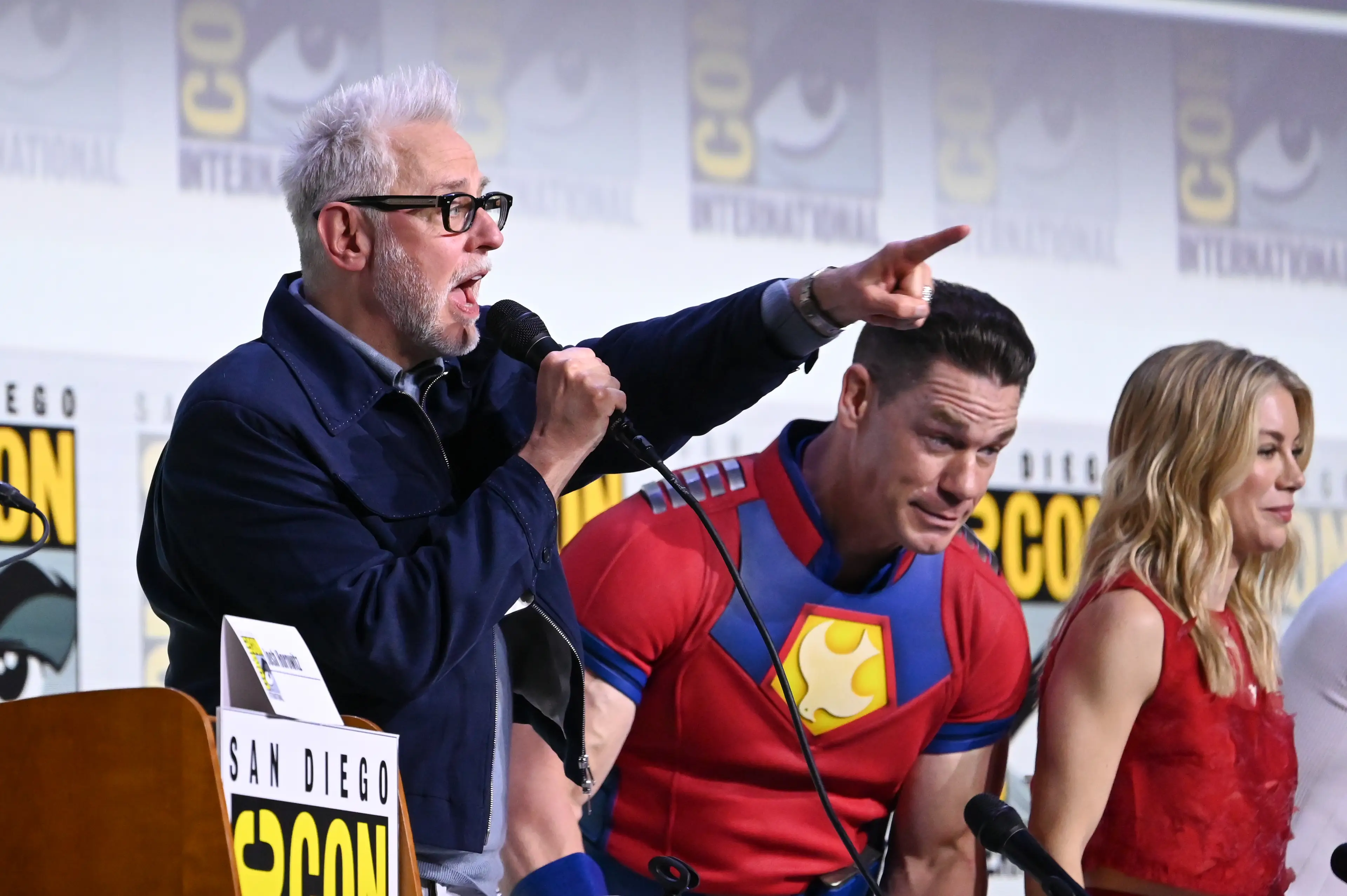 James Gunn, John Cena, Jennifer Holland. Image: Katie Flores / Contributor via Getty