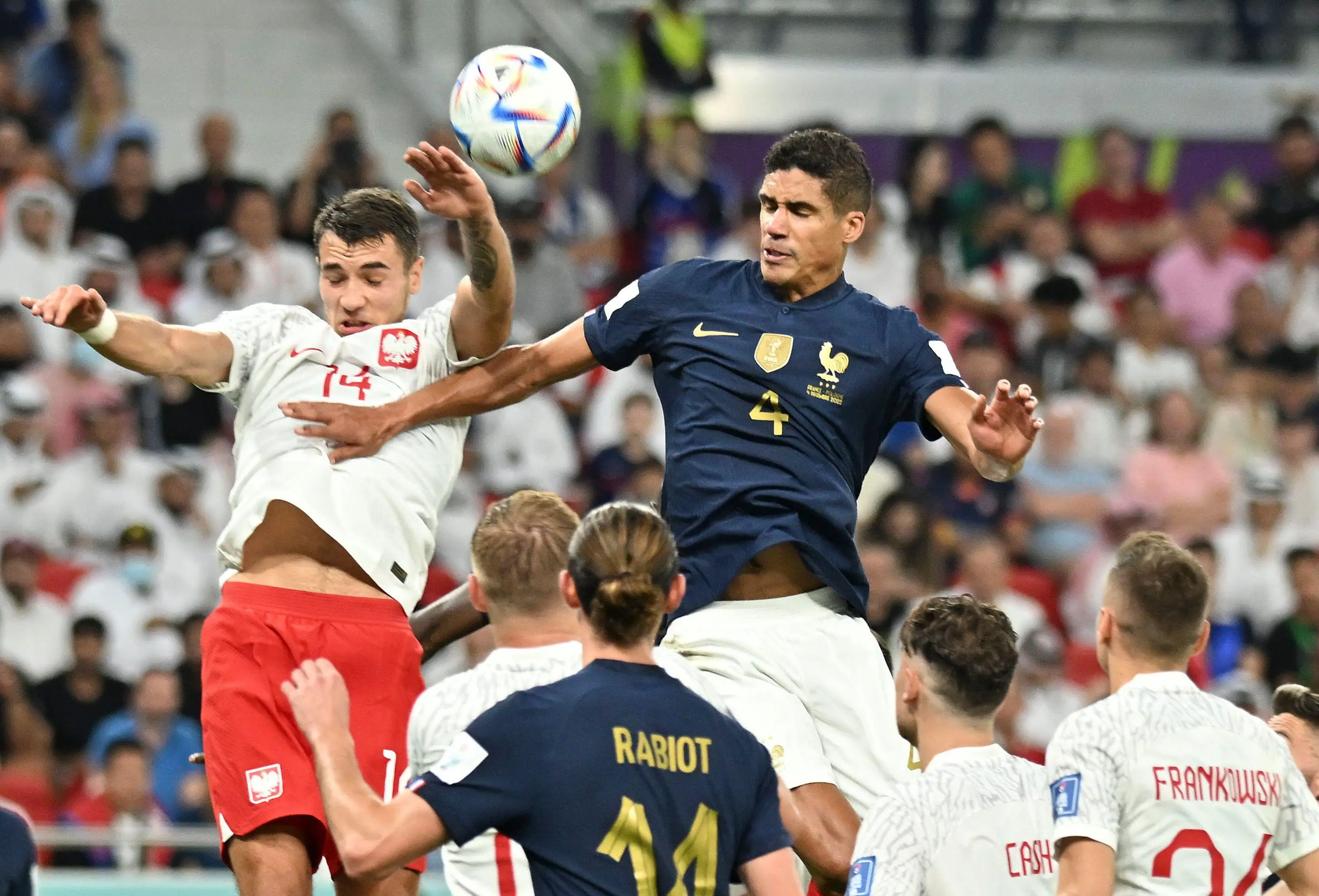 Varane battles with Jakub Kiwior of Poland. (Image
