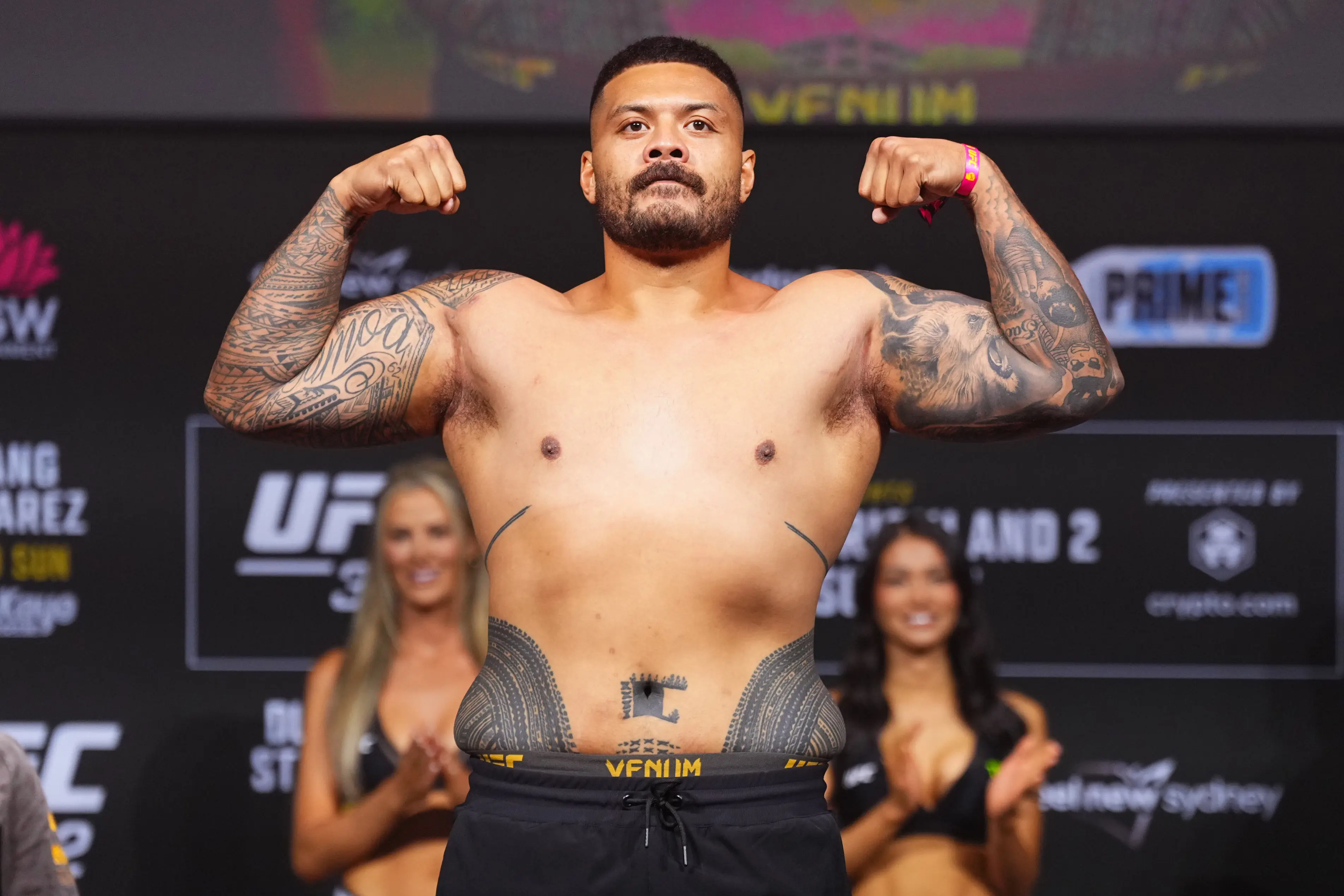Justin Tafa poses on the scale during the UFC 312 ceremonial weigh-in. Image credit: Getty