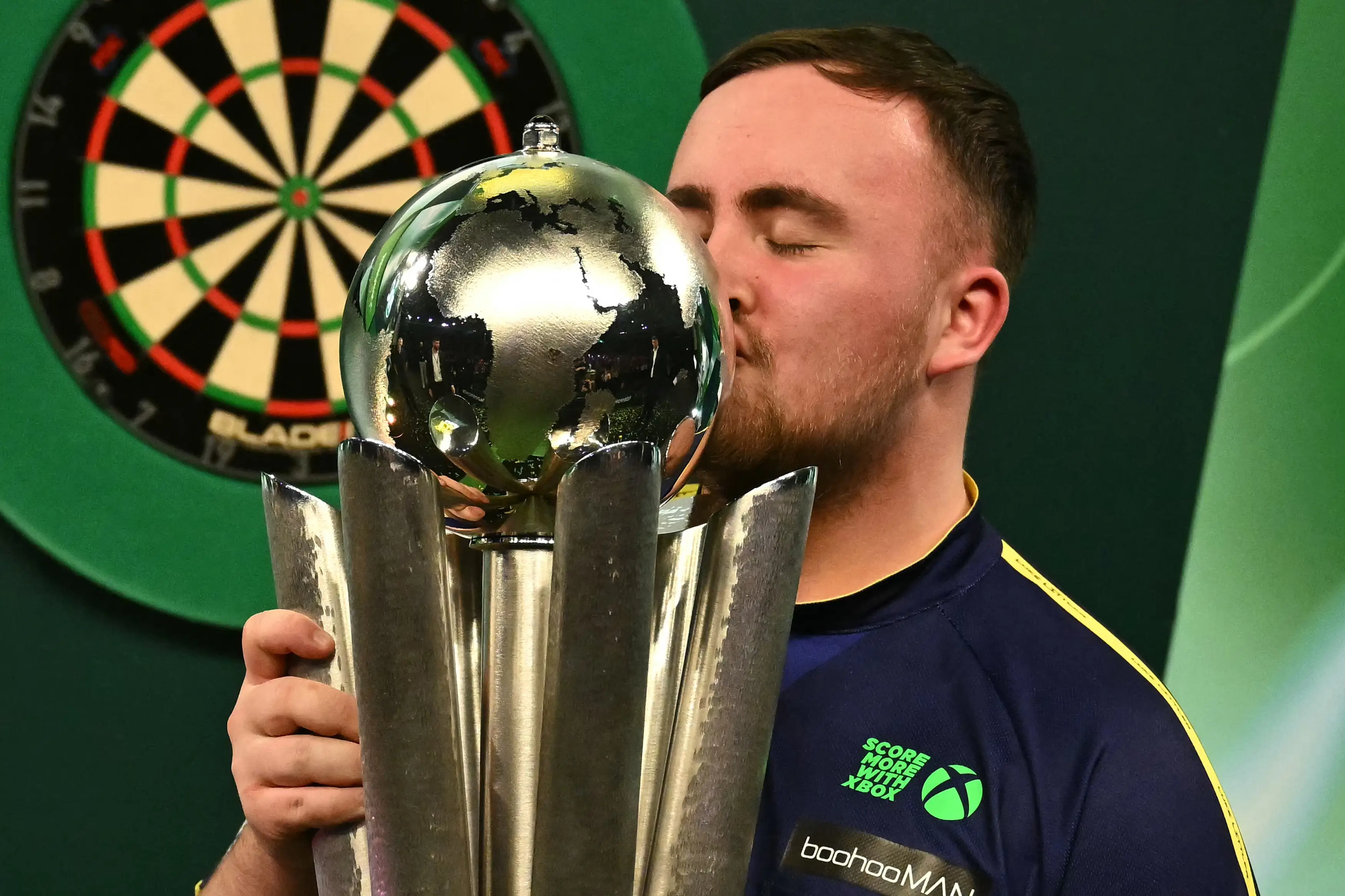 Luke Littler with the World Championship trophy (Image: Getty)