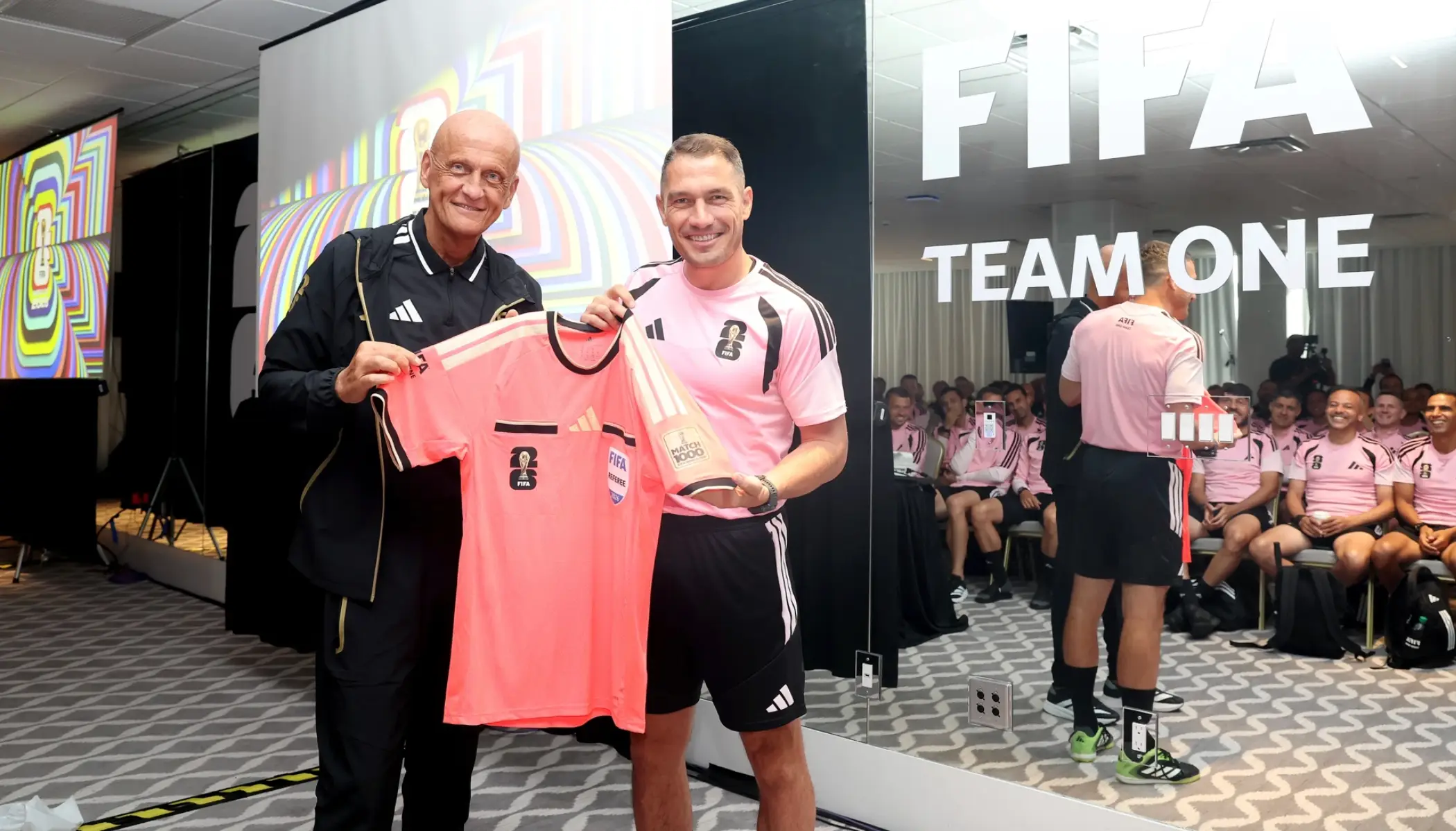 Collina and Kovacs pose with the special jersey. Image credit: FIFA