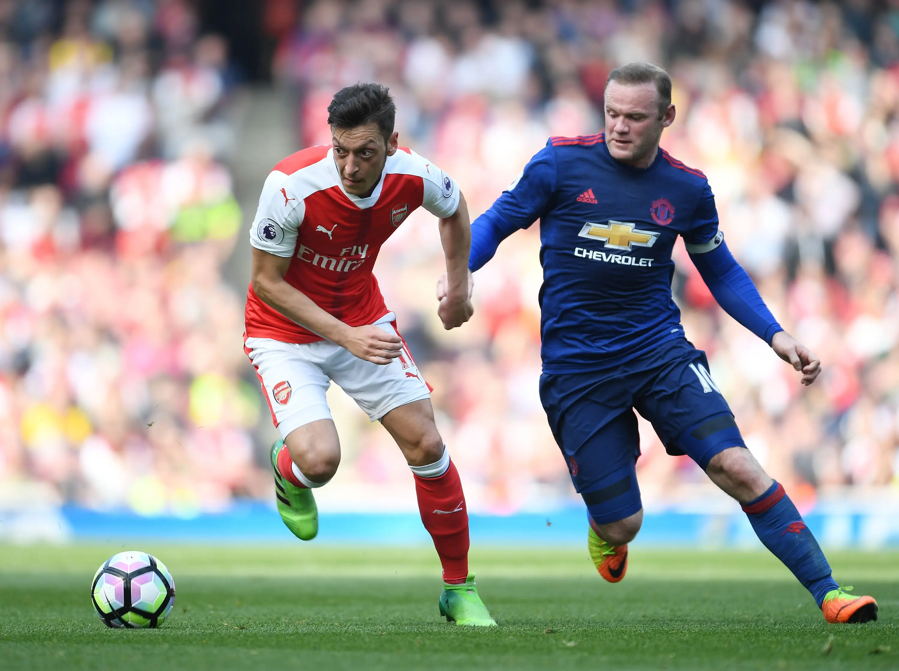 Mesut Ozil and Wayne Rooney during a fixture between Arsenal and Manchester United. Image: Getty 