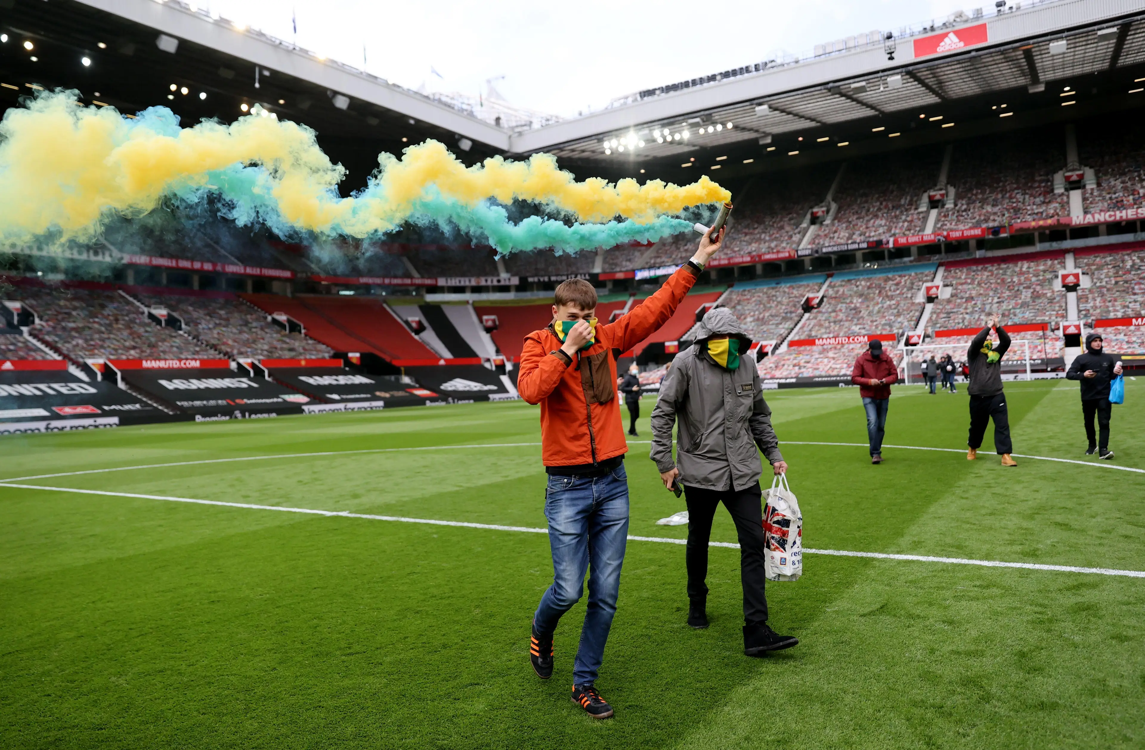 A fan with a flare on the Old Trafford pitch. (Image