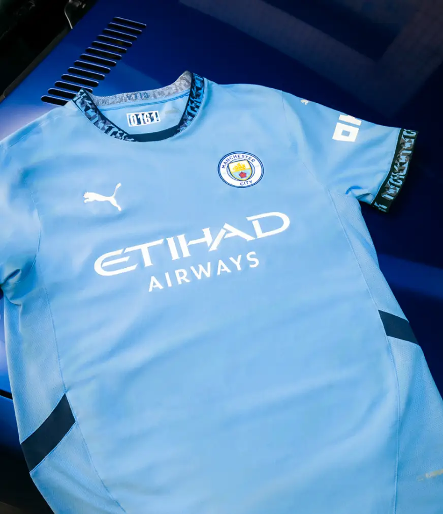 The kit features navy accents around the collar.