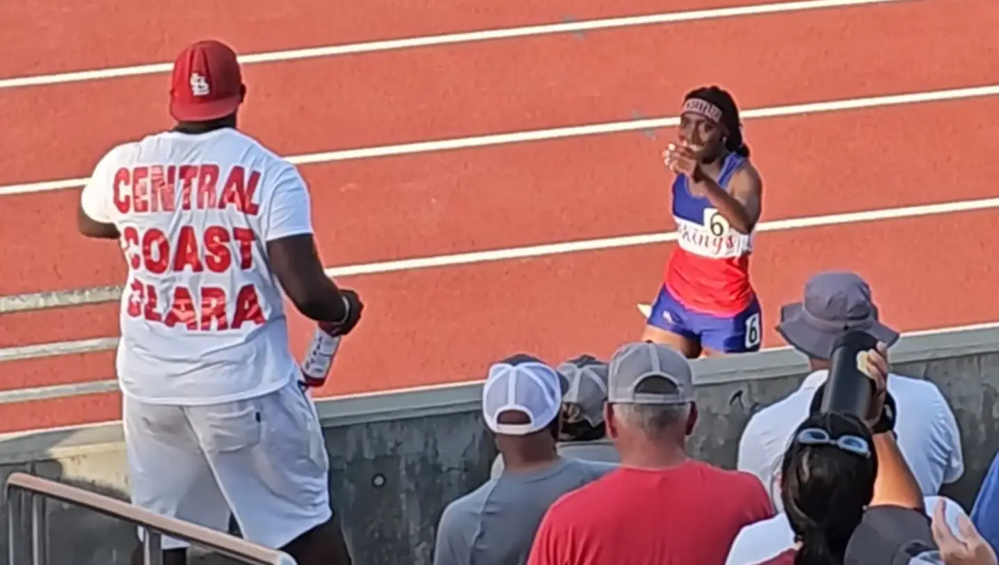 Clara Adams celebrates with her father after winning the race before being disqualified. Image: YouTube/Oceanside Dolphins Track Club
