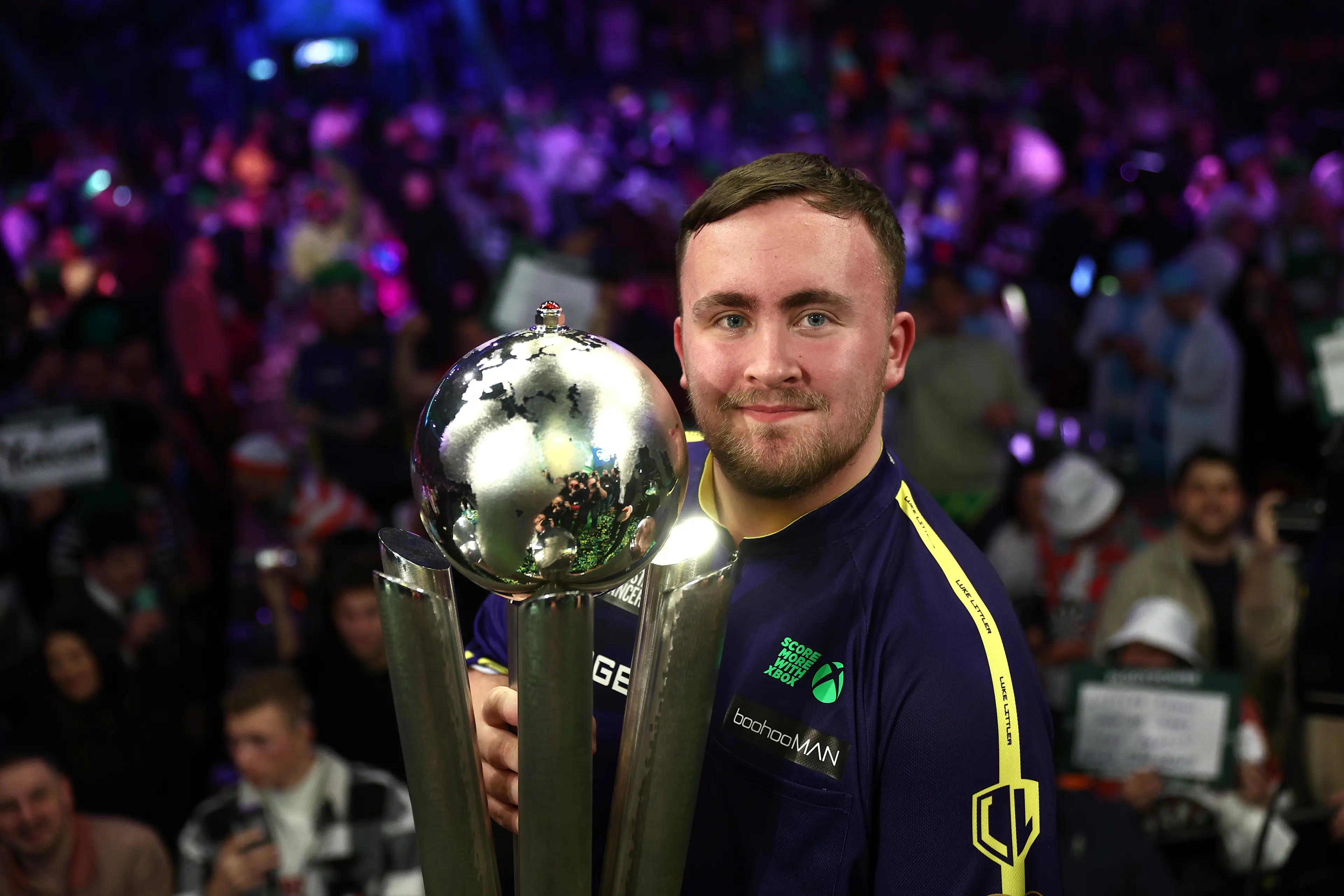 Luke Littler holds aloft the World Darts Championship trophy following his triumph. Image: Getty 