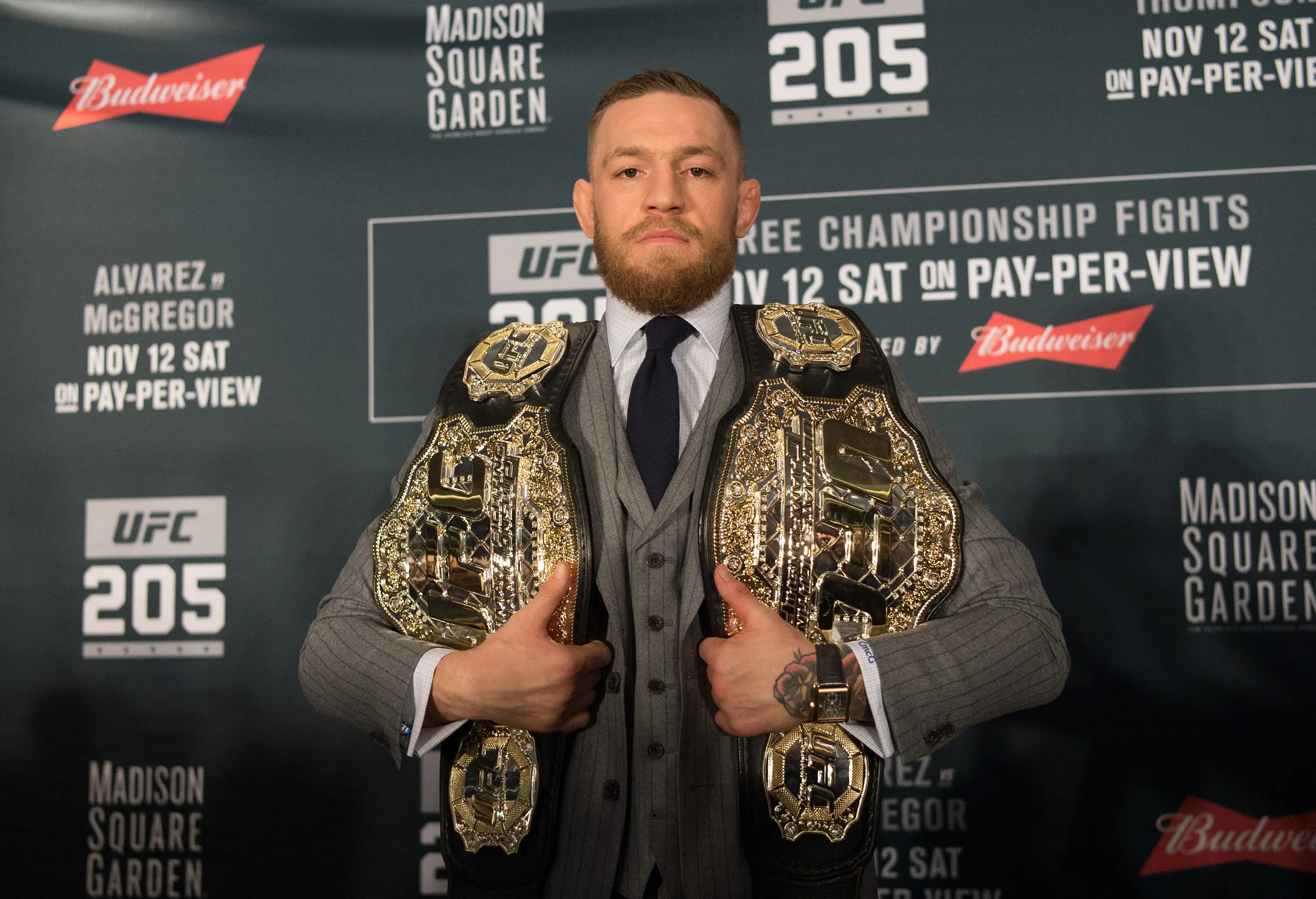Conor McGregor poses with the UFC featherweight and UFC lightweight titles at UFC 205. Image: Getty