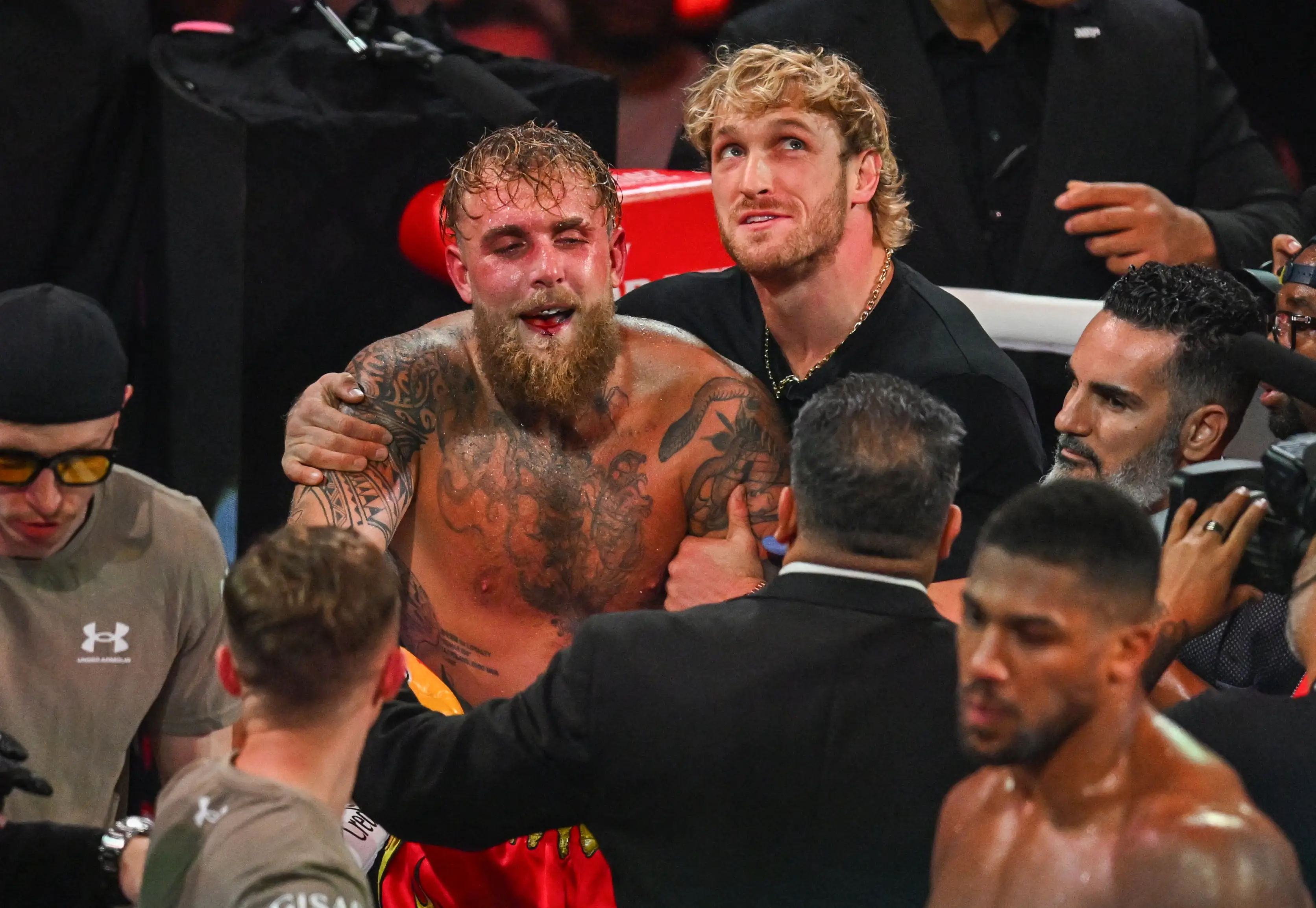 Logan Paul consoles Jake Paul after his defeat to Anthony Joshua. Image: Getty 