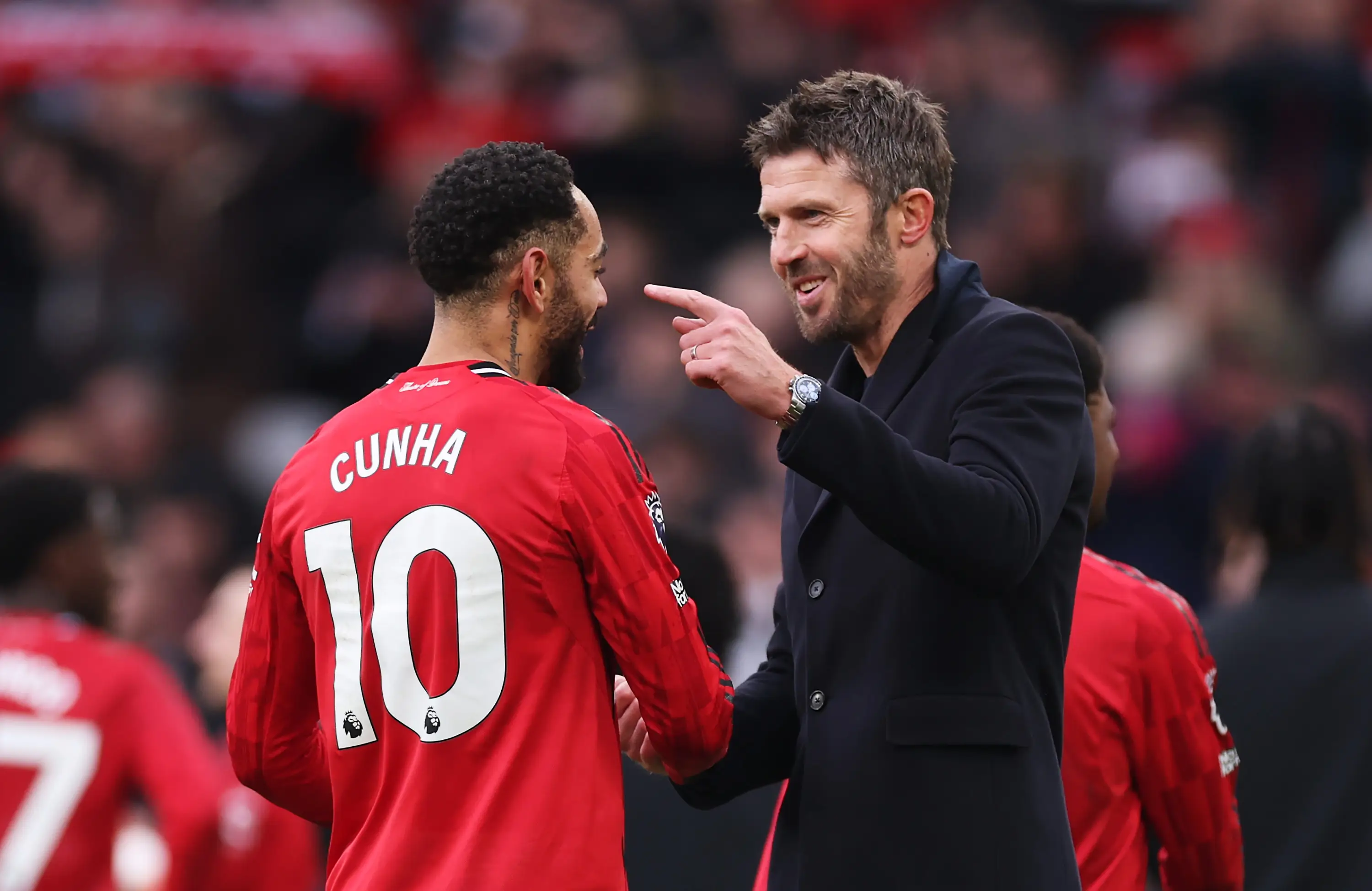 Michael Carrick celebrating a derby victory with Matheus Cunha (Image: Getty)