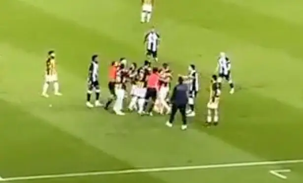 A fight between the two clubs breaks out after Clark's punch.