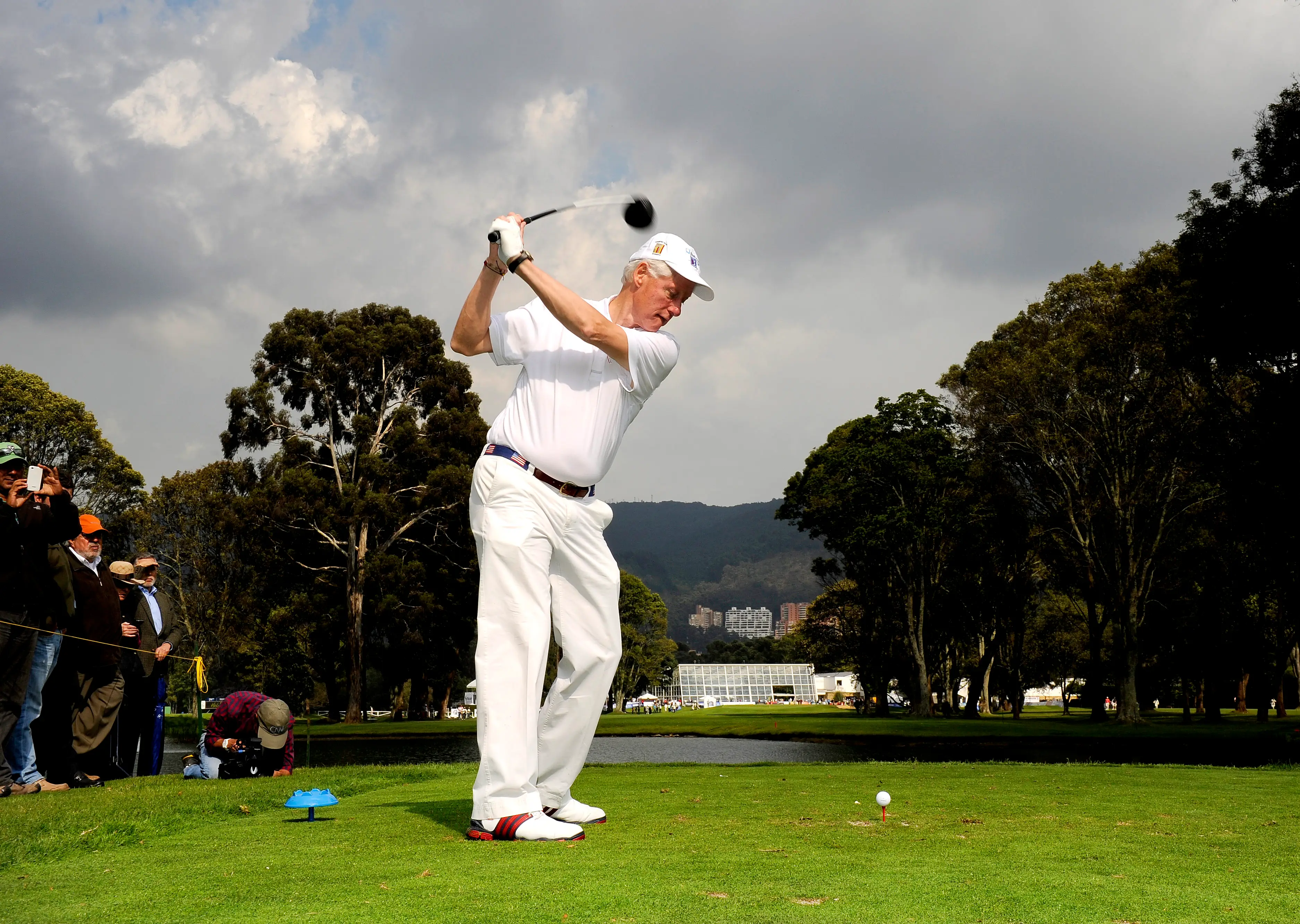 Bill Clinton plays a tee shot on the ninth hole during a round of golf. Image: Getty 