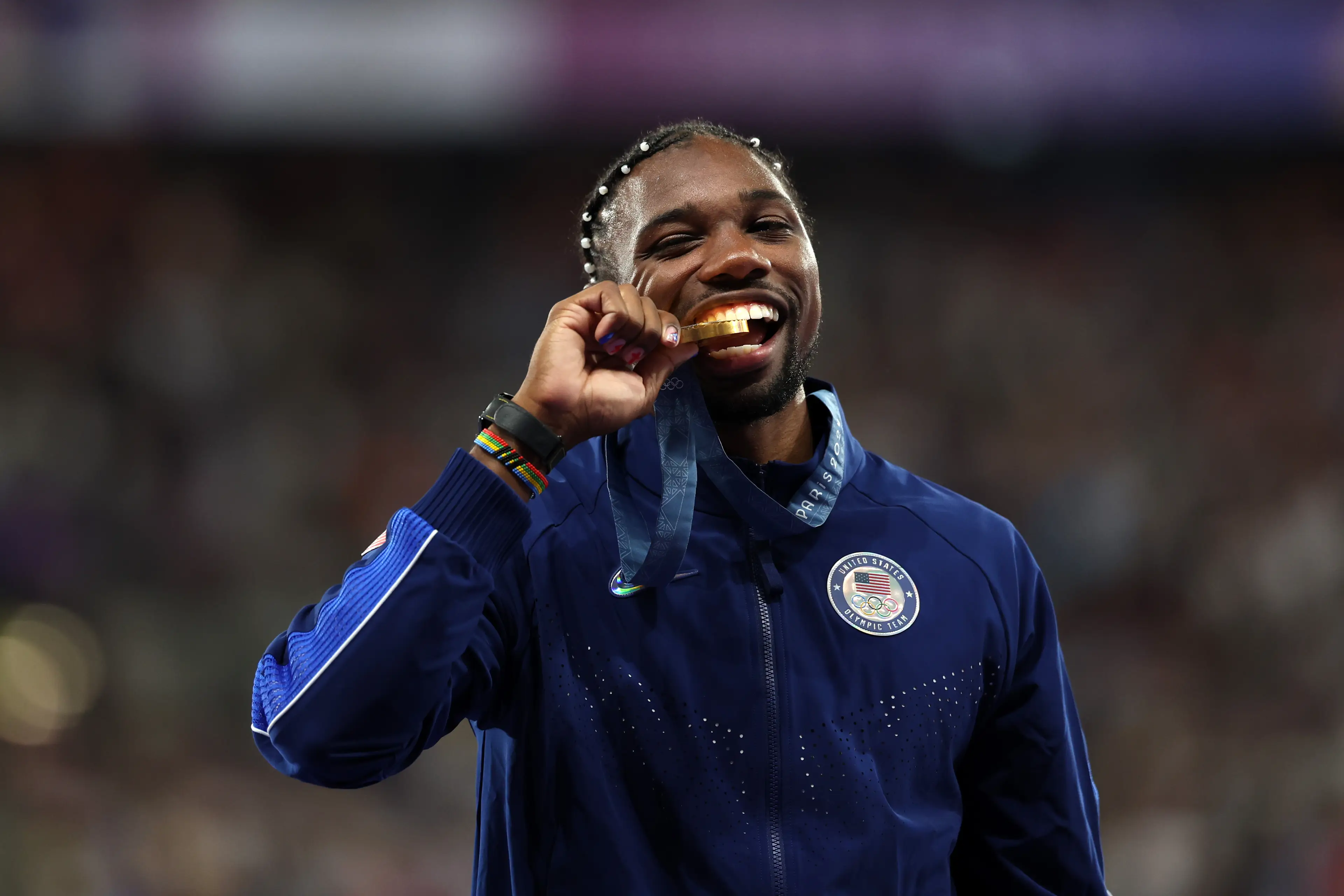 Noah Lyles celebrates on the podium. Image: Getty