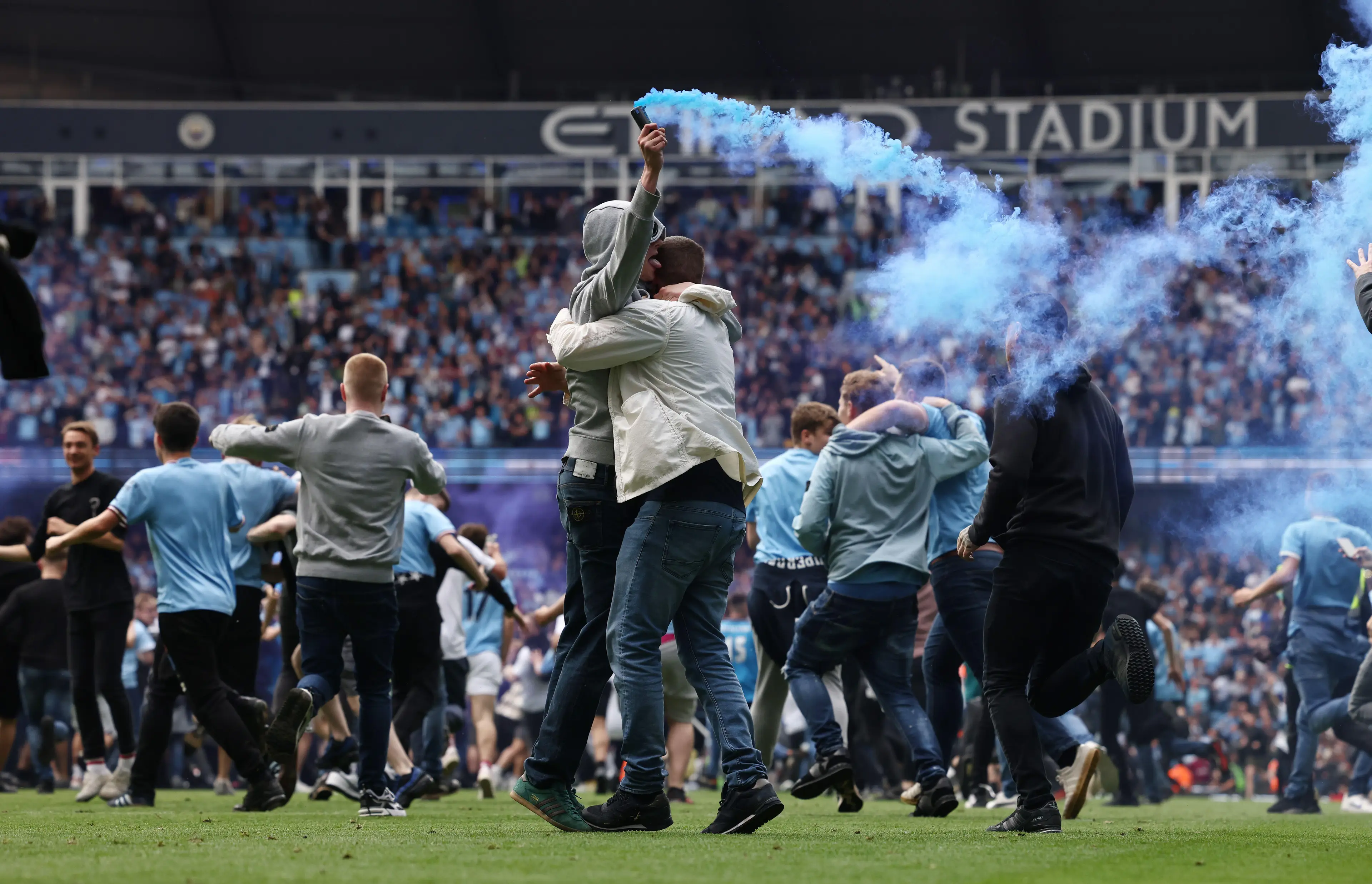 City fans embrace on the pitch. Image: PA Images