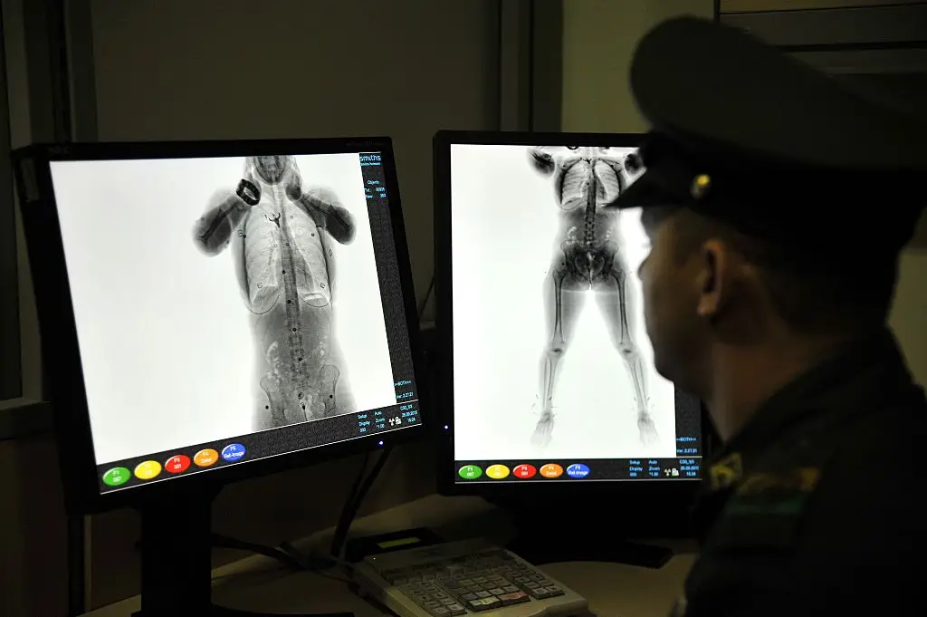 Men are given a warning ahead of their next trip to the airport (GUILLERMO LEGARIA / Stringer / Getty)