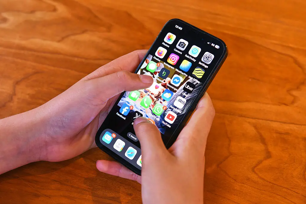 An iPhone being held by a teenager (Getty Images)