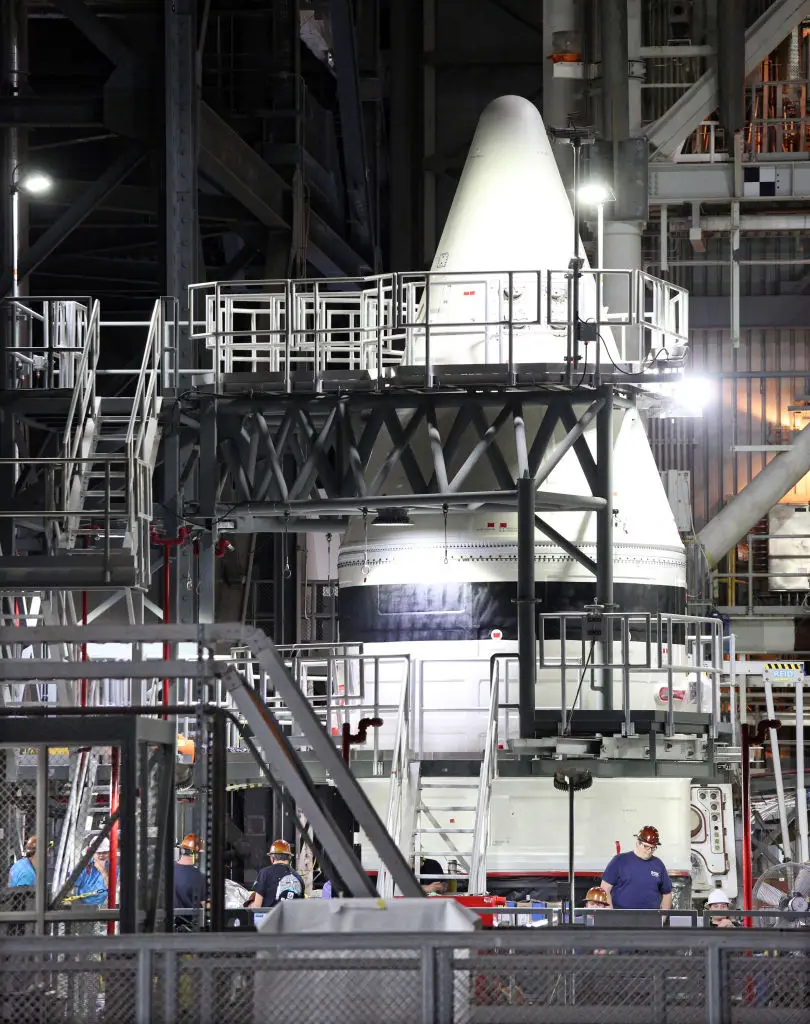 NASA engineers work alongside the tip of a solid rocket booster for the Artemis II Space Launch System (SLS) (Gregg Newton/AFP/Getty Images))