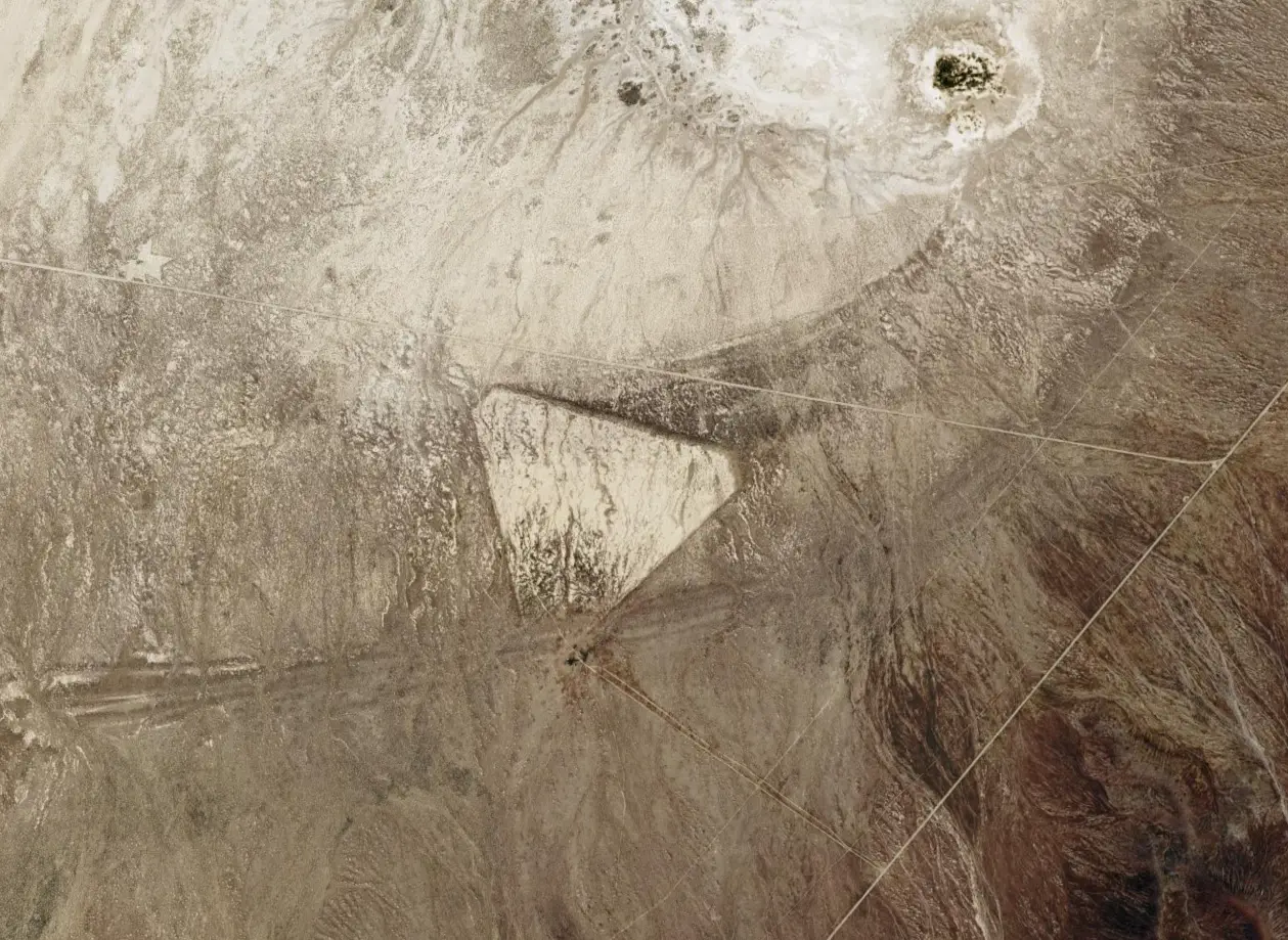 The triangle is likely the remnants of an old airfield that's since been unpaved in the desert (Google Earth)