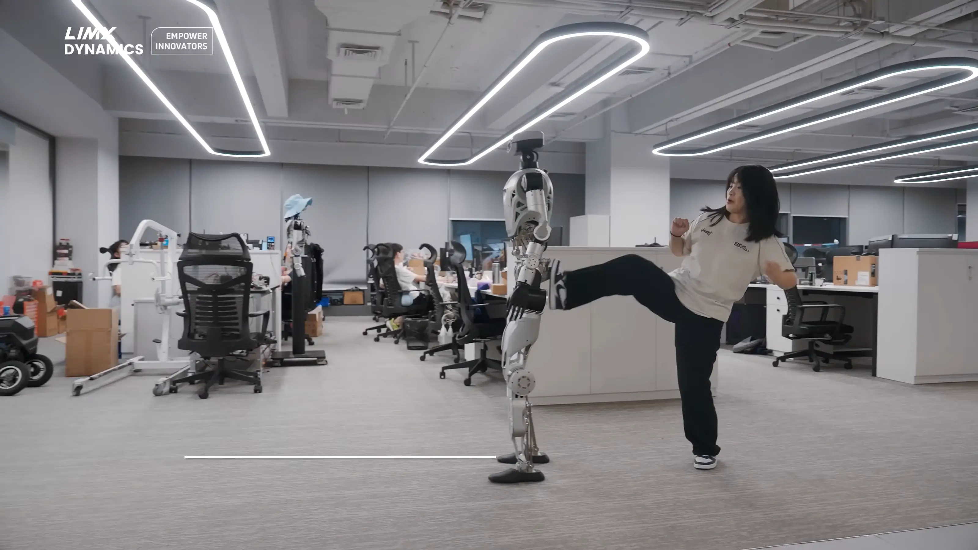 Oli gets a kicking from a human coworker for slacking off (YouTube/LimX Dynamics)