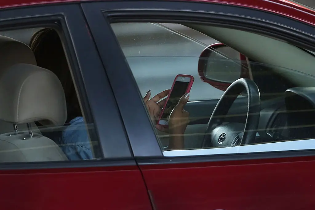 Going on your phone while driving could trigger an in-car alarm if you look away from the road for more than 3.5 seconds (Spencer Platt/Getty Images)